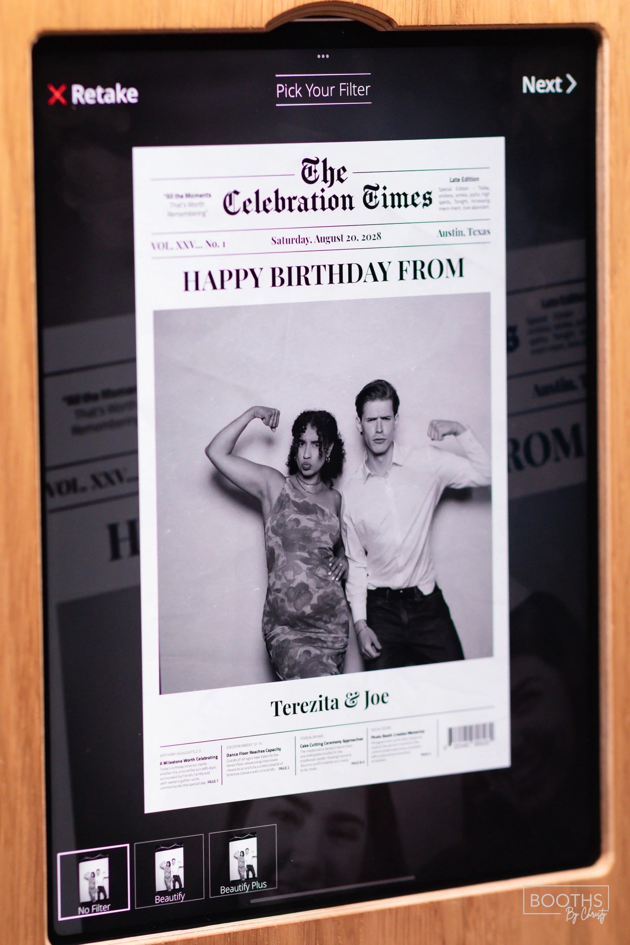 Digital tablet screen displaying a black and white photo of a man and a woman, both flexing their muscles. The screen shows a newspaper-style template with the headline 'HAPPY BIRTHDAY FROM Terezita & Joe,' and the date August 20, 2028. The tablet is