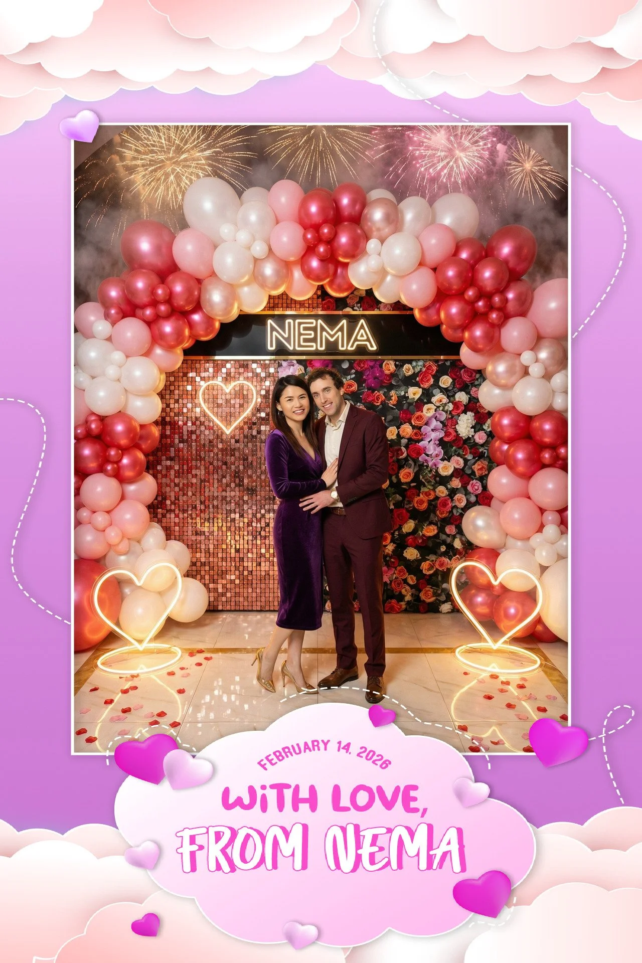 A couple dressed in formal attire standing in front of a heart-shaped balloon arch at a decorated photo booth, with fireworks in the background and a sign that says 'NEMA'. The woman is wearing a purple dress and gold heels, and the man is in a burgu