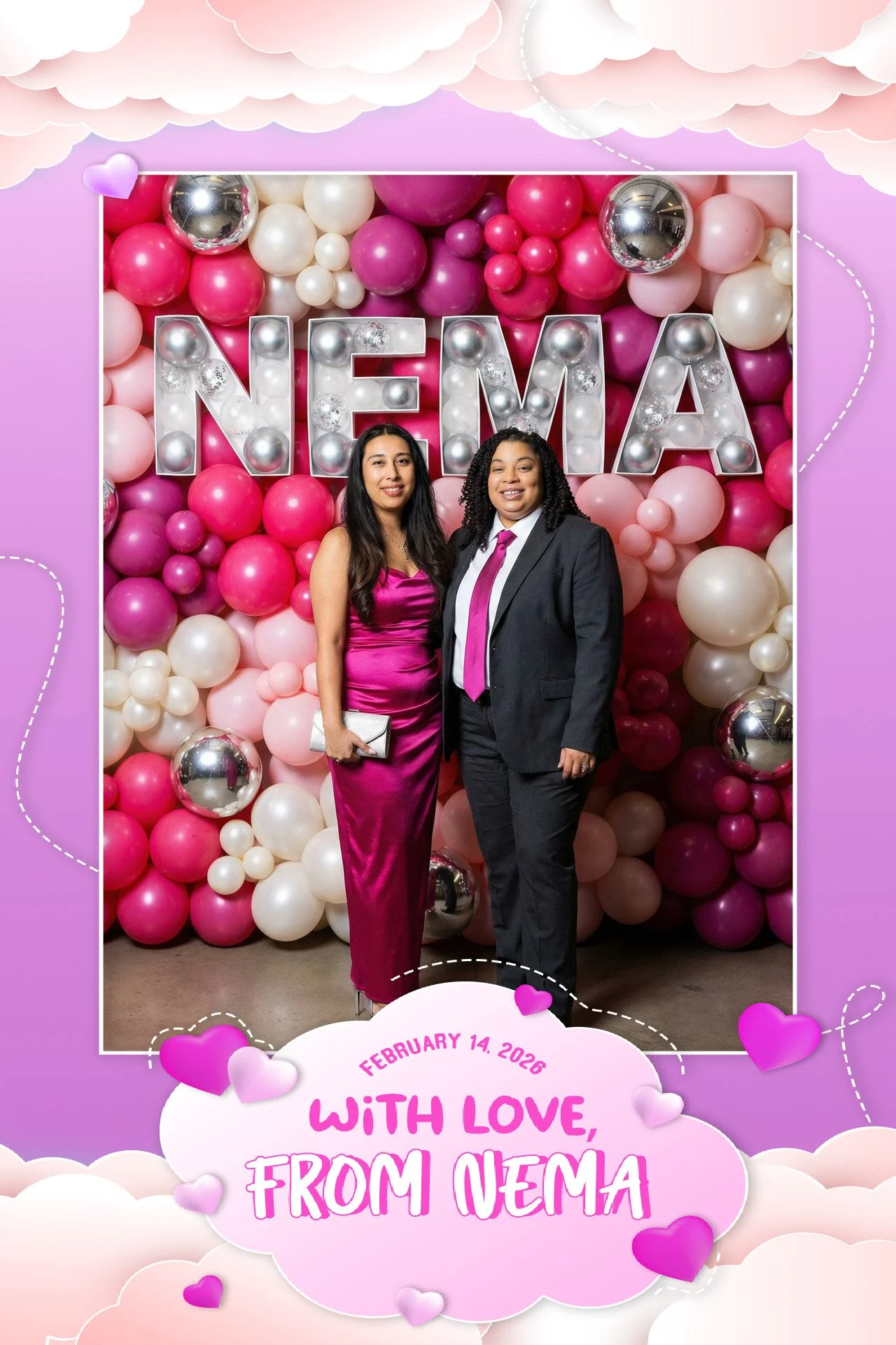Two women in formal attire standing together in front of a balloon wall with large illuminated letters spelling NEMA, celebrating February 14, 2026, with a pink and purple themed decorative backdrop and a message reading 'With love, from NEMA' at the