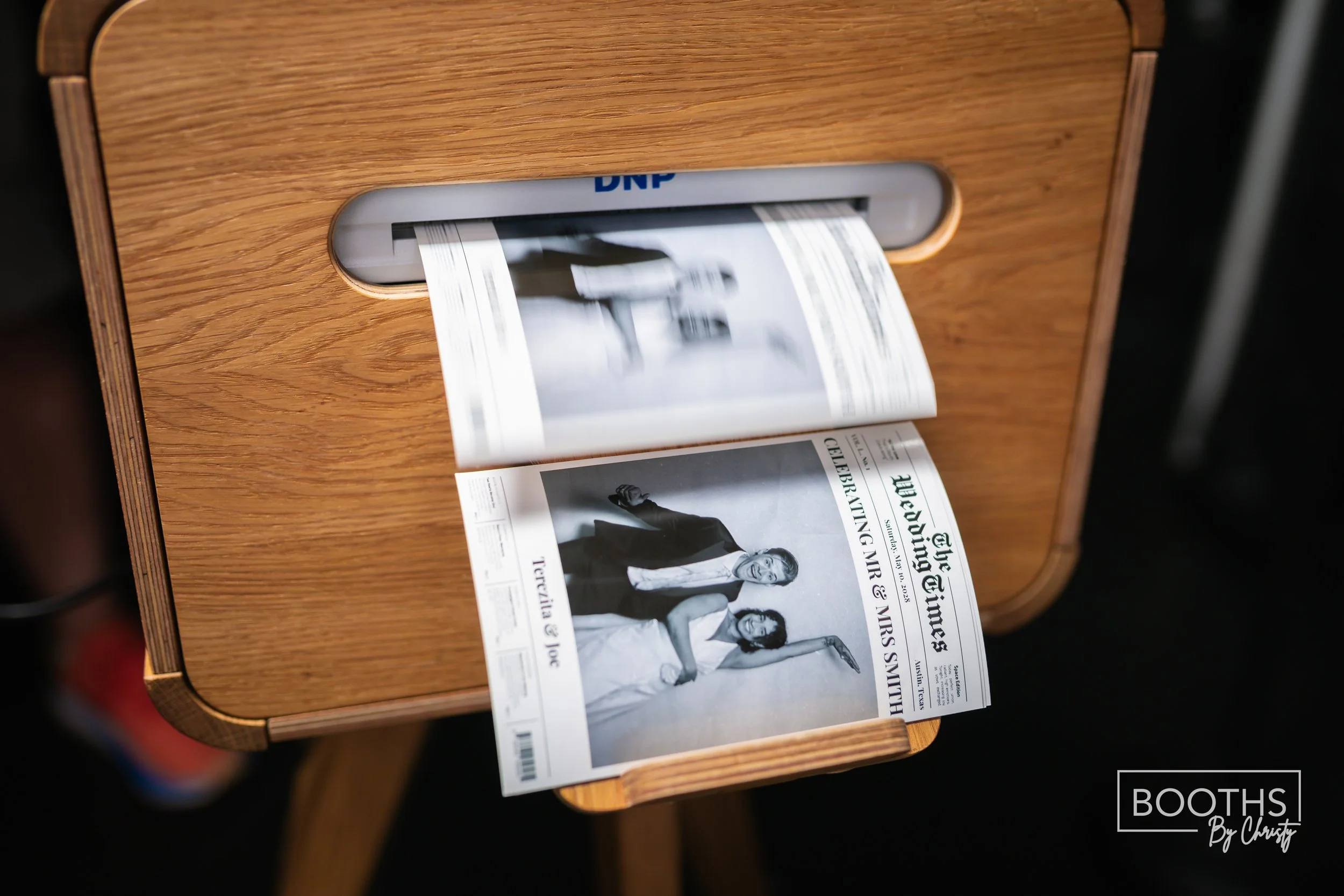A newspaper is being printed from a wooden newspaper printing machine.