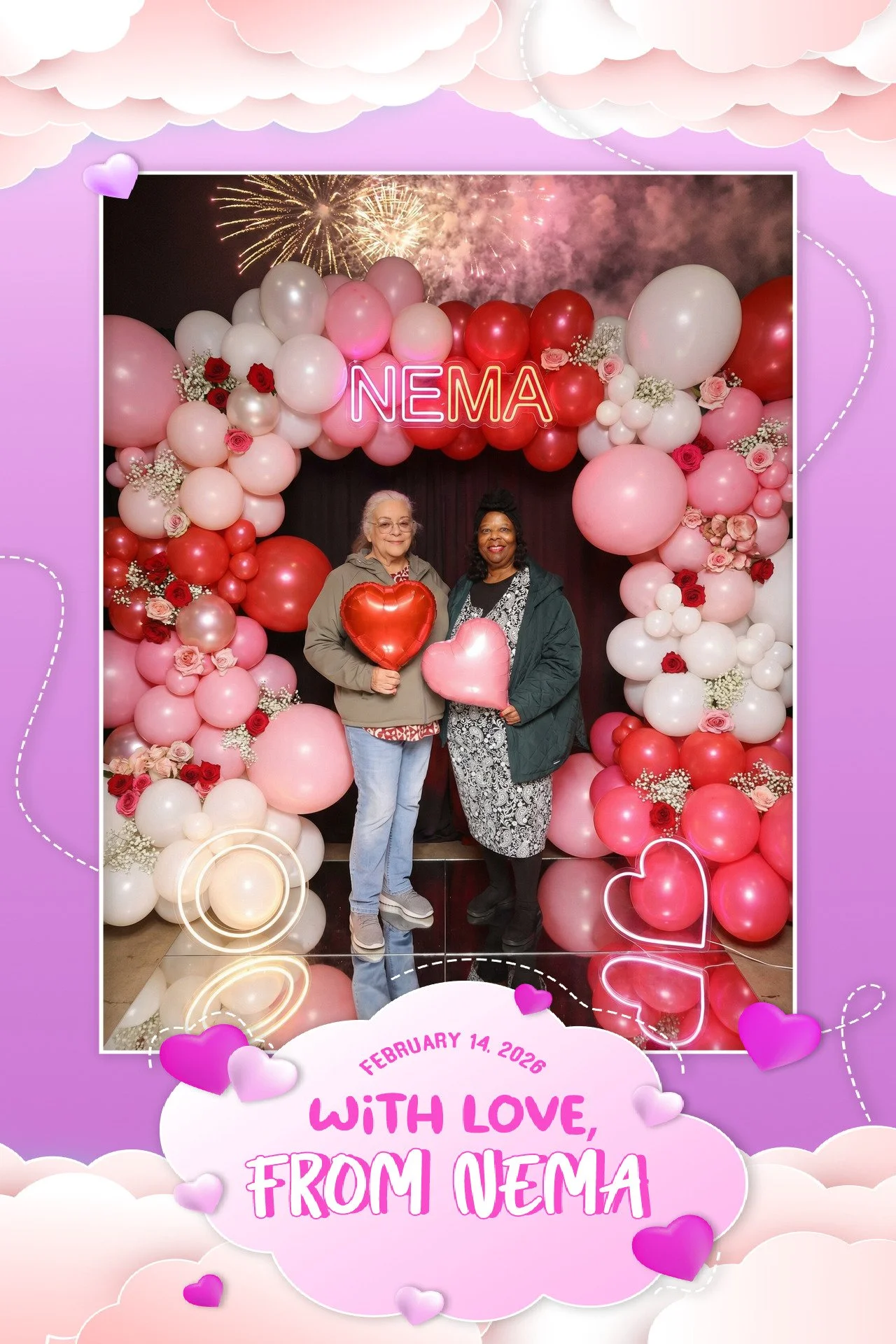 Two women smiling and holding heart-shaped balloons, standing in front of a pink and red balloon arch with a neon sign reading 'NEMA,' as fireworks light up the night sky in the background. The image has a decorative purple border with clouds and hea
