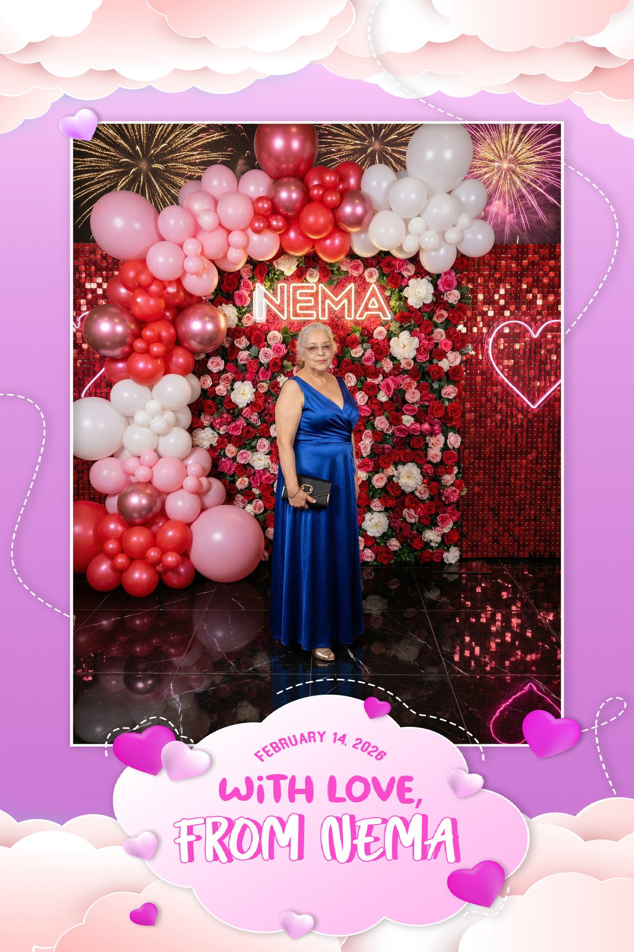An older woman in a blue satin gown holding a black clutch posing in front of a backdrop of red and white flowers, pink and white balloons, and fireworks. The backdrop has the name "NEMA" illuminated in neon. There is a pink cloud design at the botto