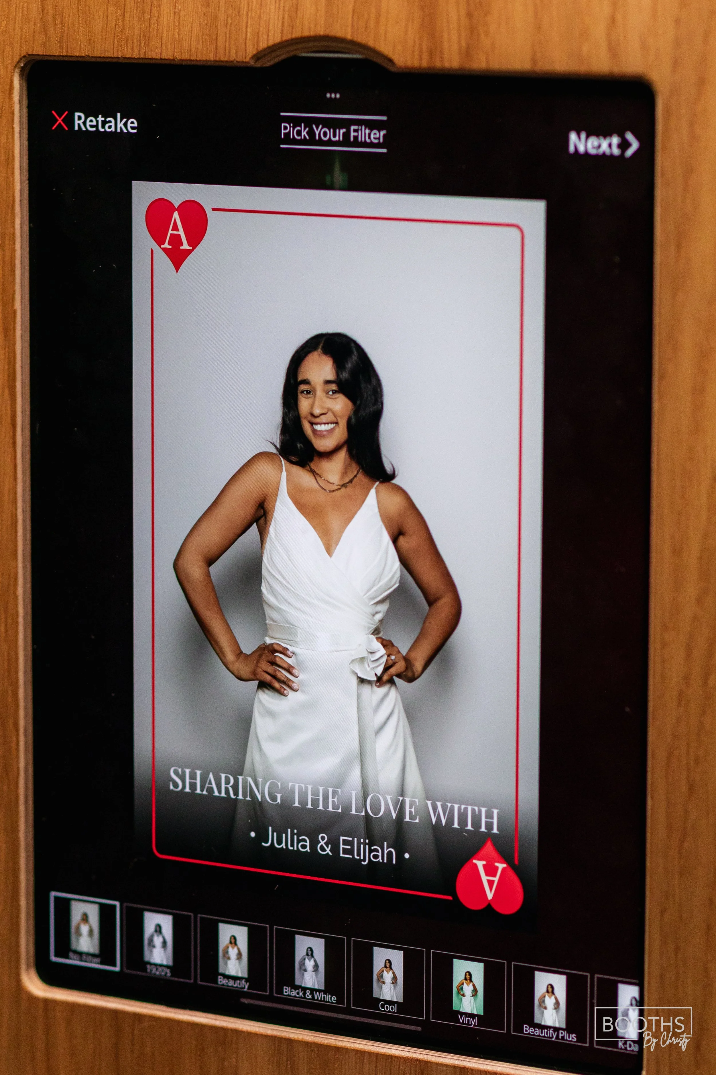 Digital display showing a portrait of a woman in a white dress, logo of the Ace of Hearts, and the text 'Sharing the Love with Julia & Elijah' underneath.