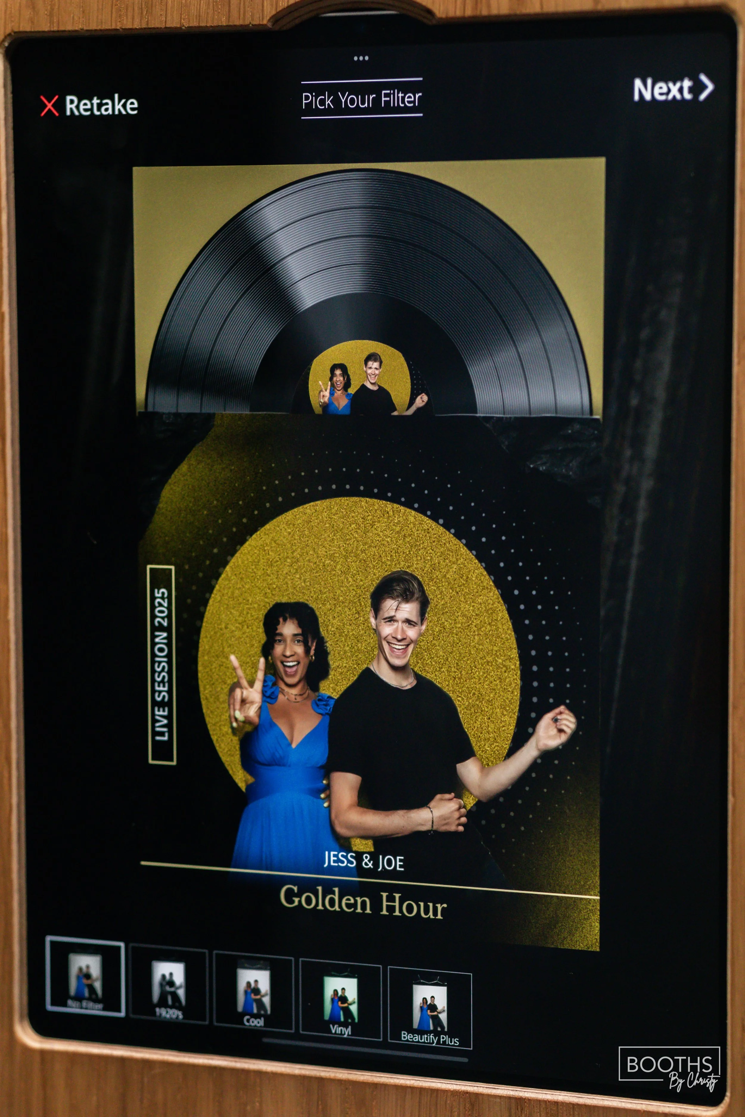 Photo booth photo featuring a young woman in a blue dress and a young man in a black shirt, both smiling and making peace signs, with a gold and black background labeled "Golden Hour."