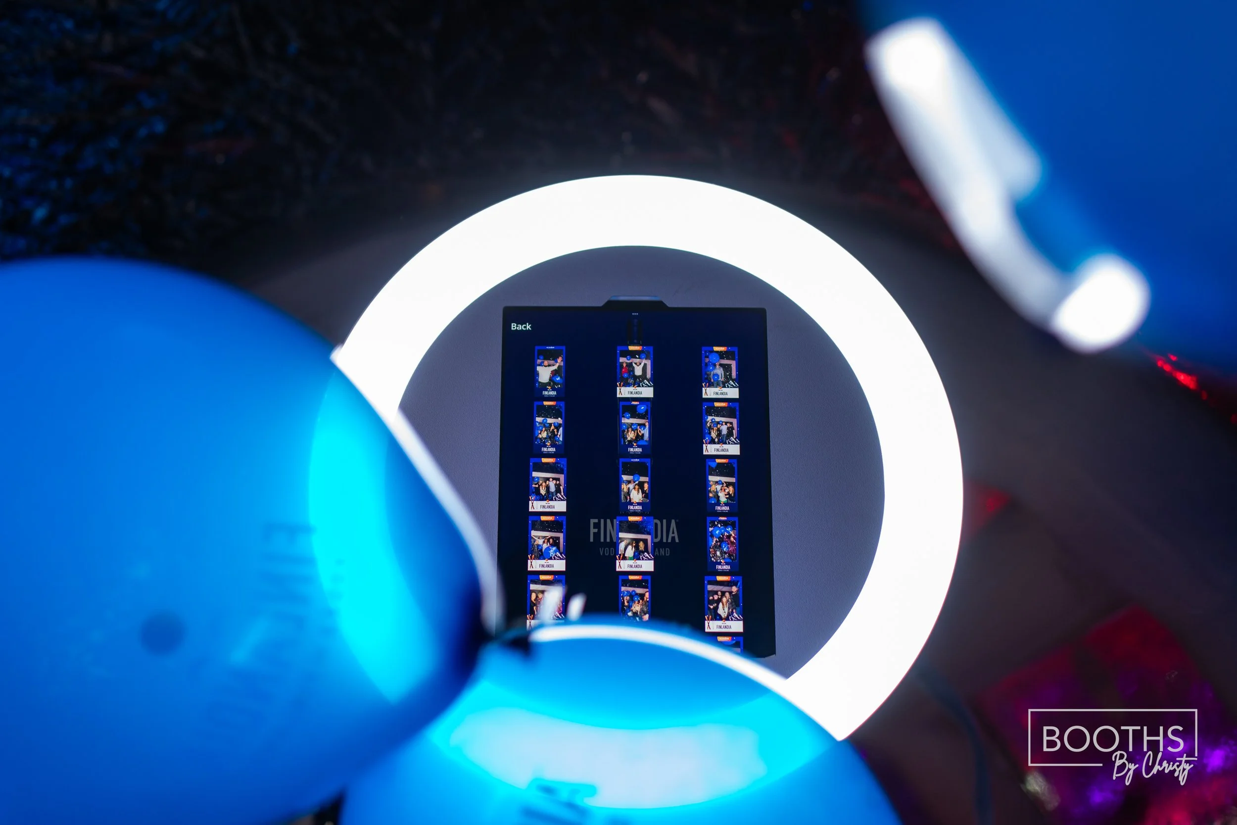 A smartphone displays a grid of photo thumbnails against a dark background with a large circular light source behind, creating a glow around the phone.