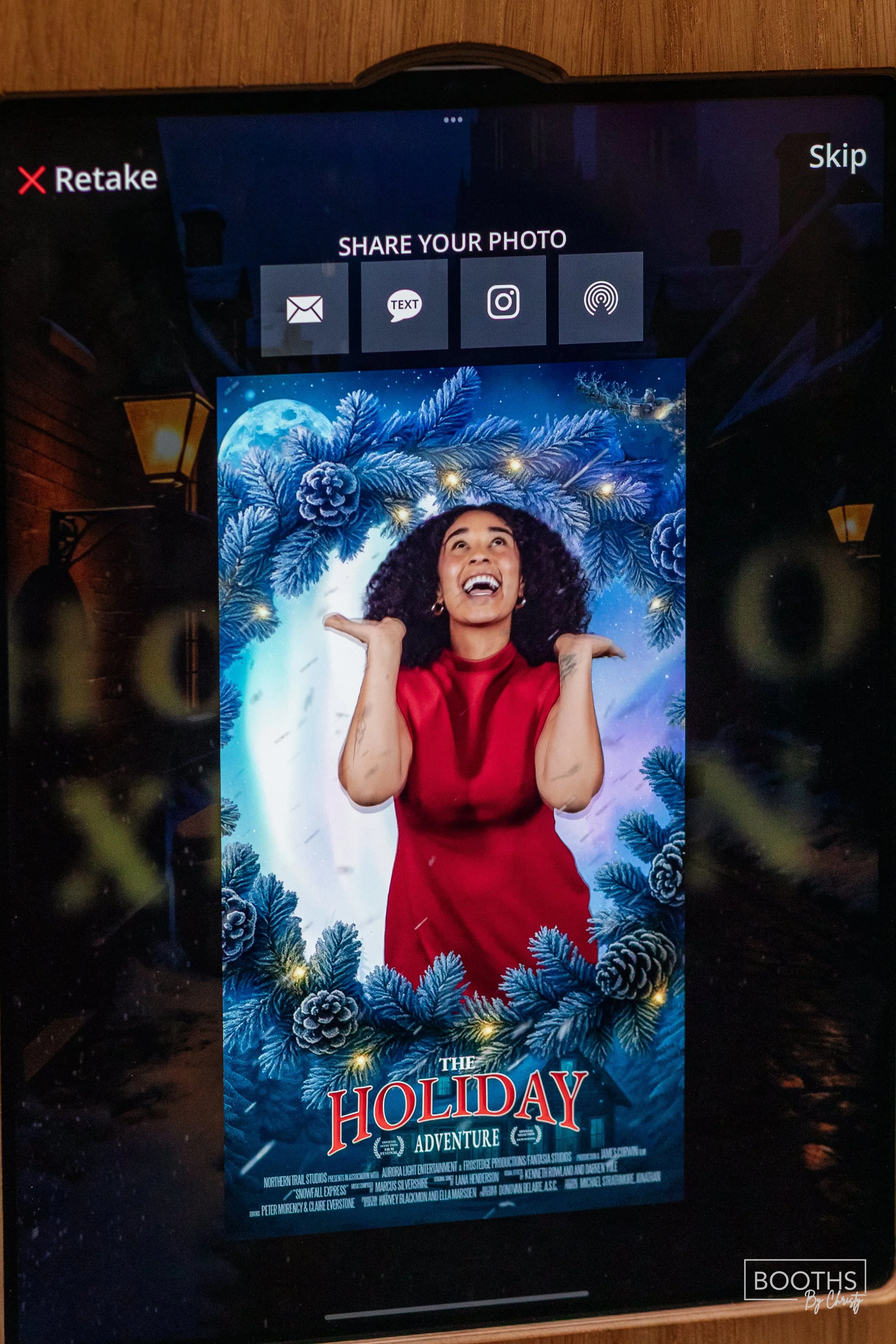 Digital display promoting the holiday movie 'The Holiday Adventure' featuring a woman in a red dress surrounded by blue pine branches and pinecones in a festive winter scene.