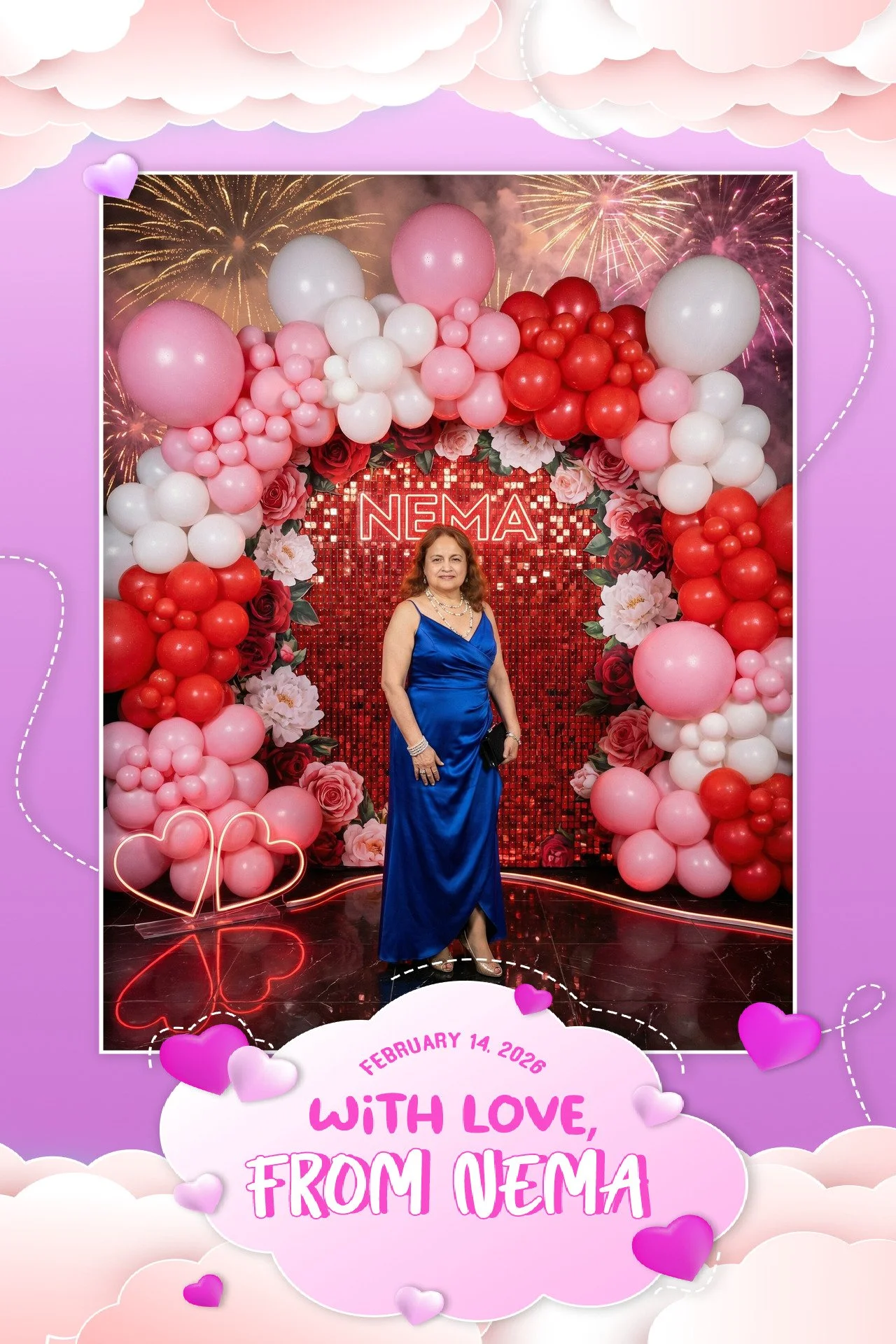 A woman in a blue dress standing in front of a decorated backdrop with balloons, roses, and fireworks images. The backdrop has the word 'NEMA' and a message with the date February 14, 2026, saying 'With love, from NEMA'.