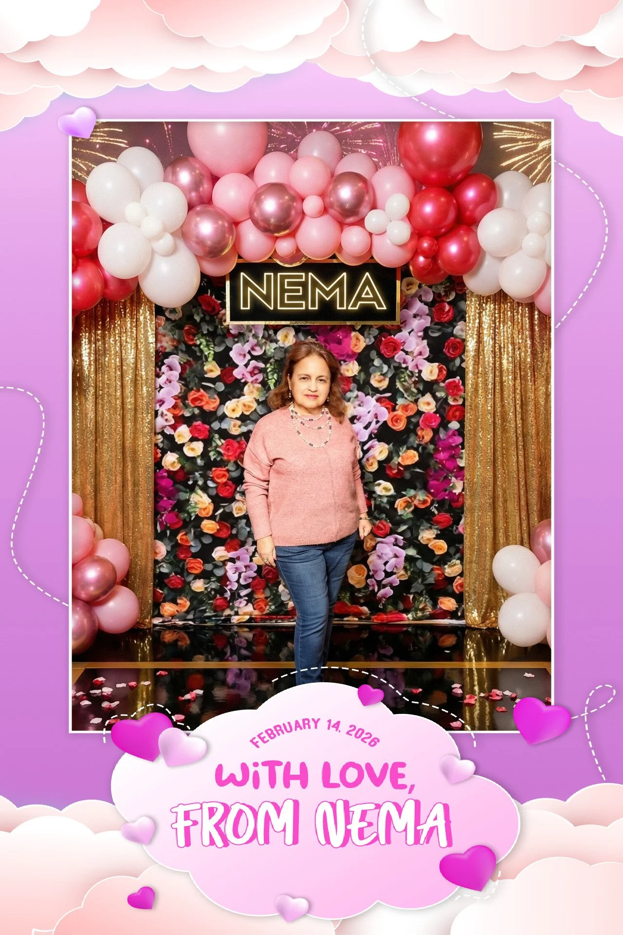 A woman standing in front of a floral and balloon backdrop with a sign that reads 'NEMA'. The backdrop features pink, red, purple, and white flowers with gold curtains. The photo is framed with purple, pink, and white clouds and hearts, and a message