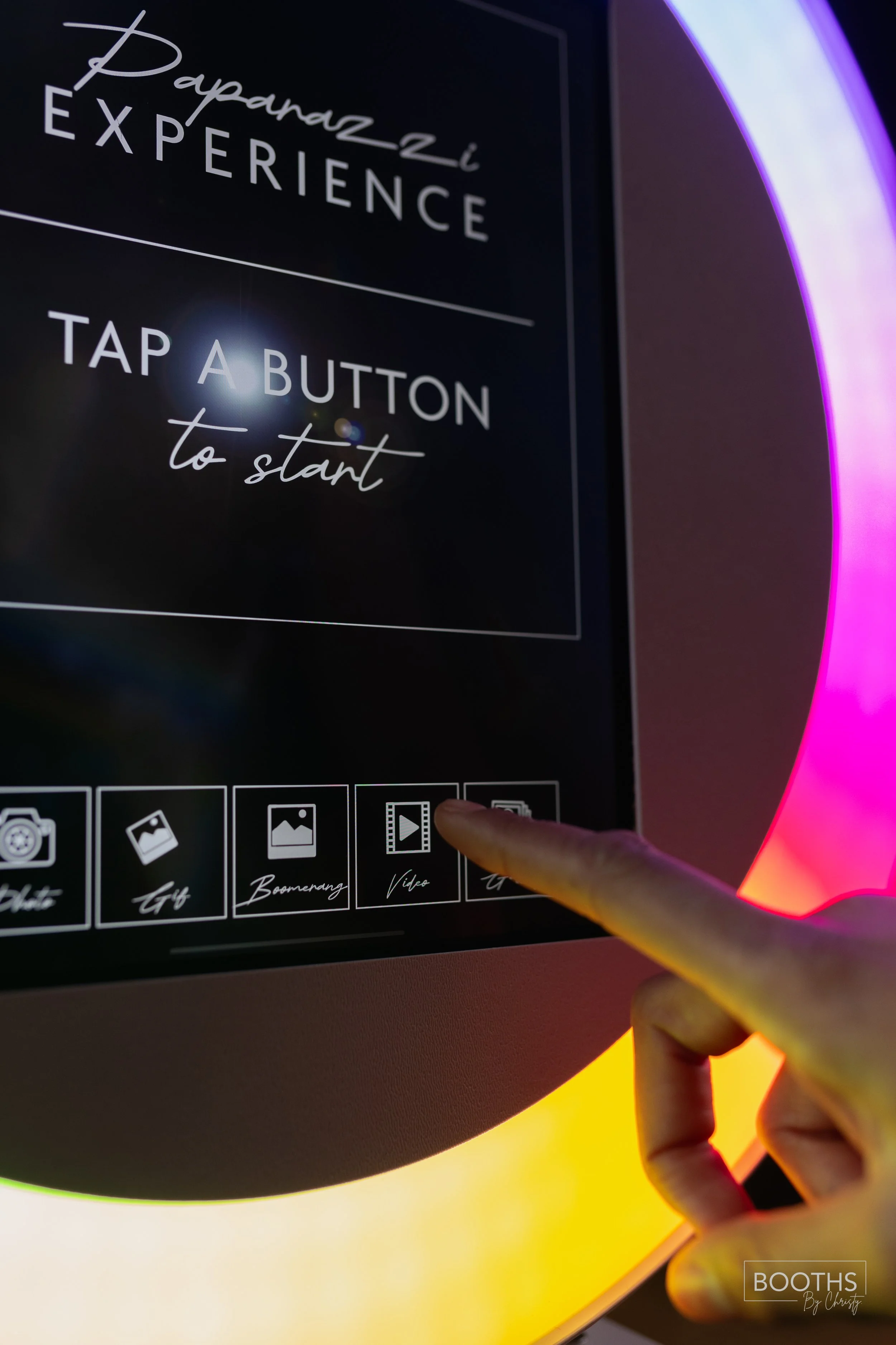 Touchscreen kiosk labeled 'Papara Zzi Experience' with options for photo, GIF, Boomerang, video, and others, with a person's finger pressing the 'video' option.