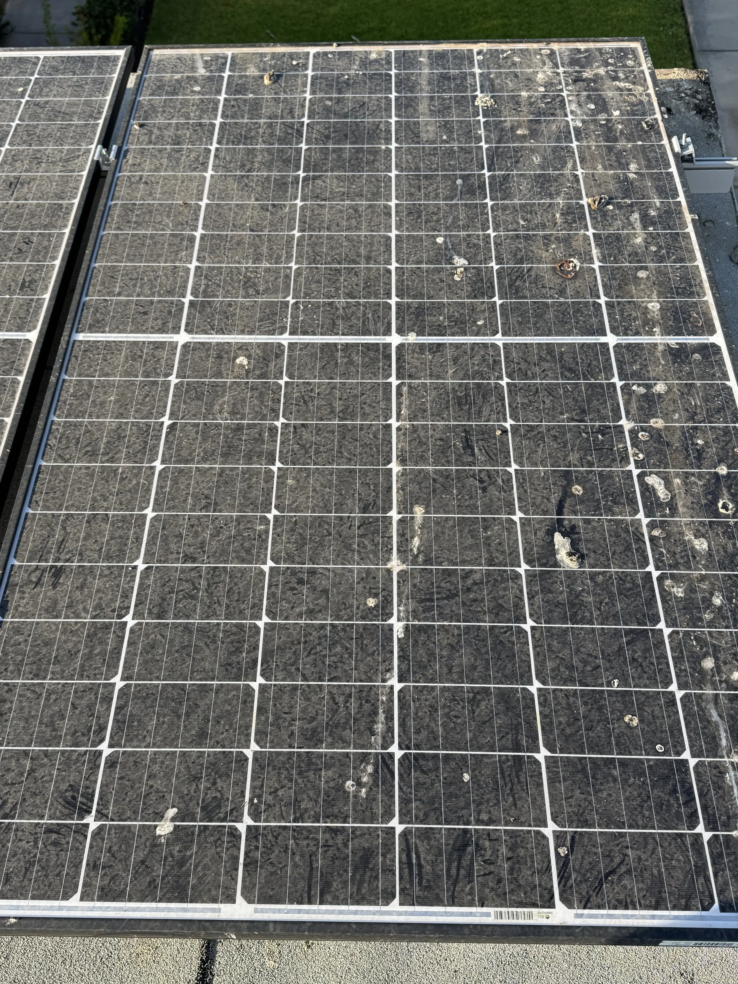 A solar panel with some dirt, debris, and damage on several of the photovoltaic cells.