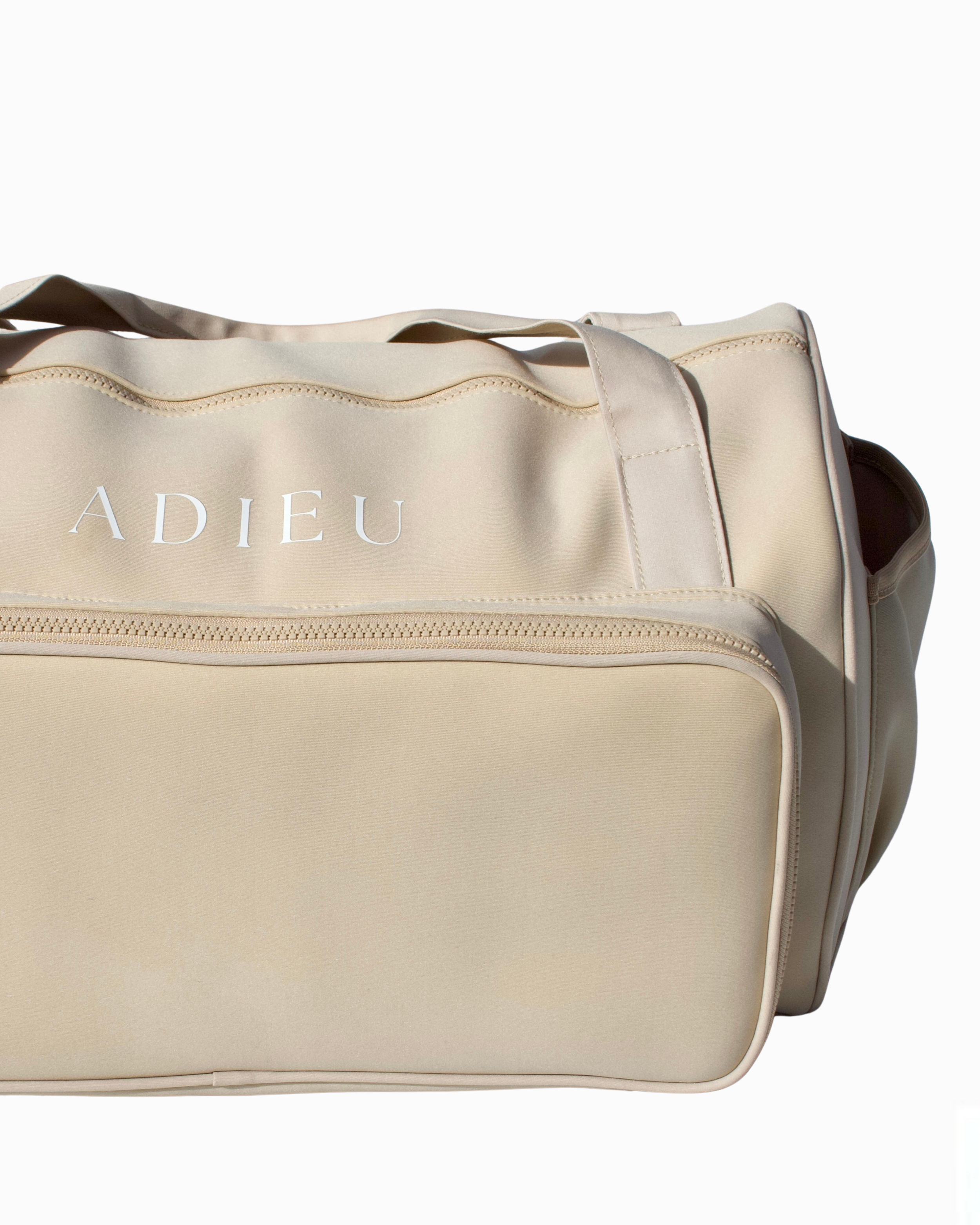 xFront view of the beige Adieu Core Duffle with top handles – women’s stylish weekender bag.