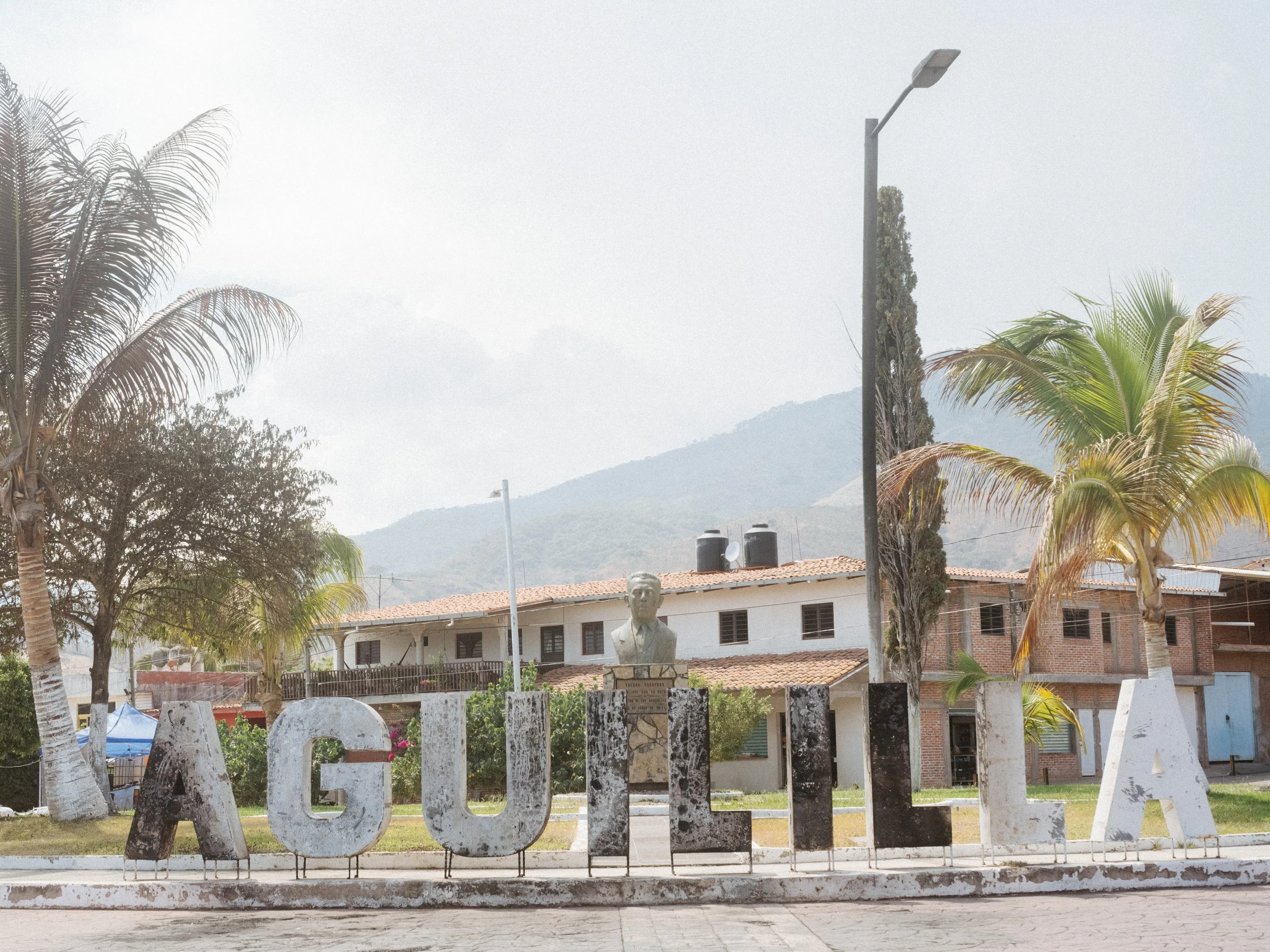 The town sign of Aguililla, Michoacán, birthplace of cartel leader Nemesio Oseguera Cervantes, shows burn marks following violence in the area.