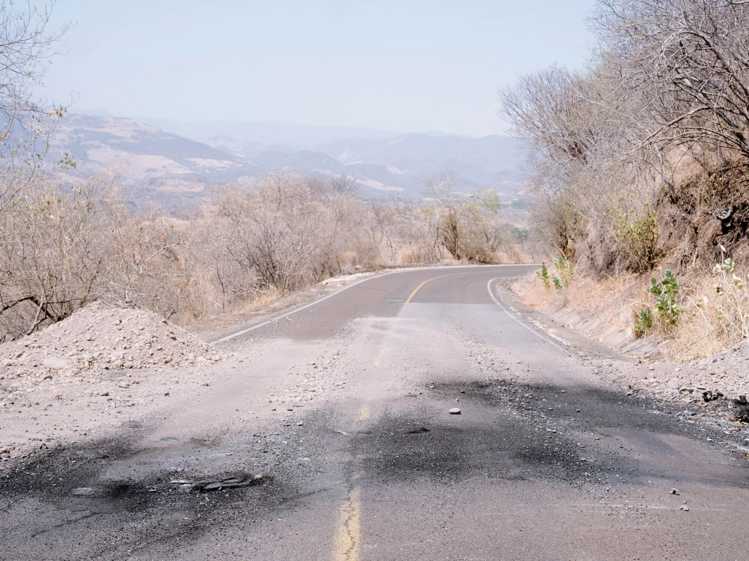 A road connecting El Aguaje and Aguililla, Michoacán, shows burn marks left by a vehicle during roadblocks following the reported capture of cartel leader Nemesio Oseguera Cervantes.