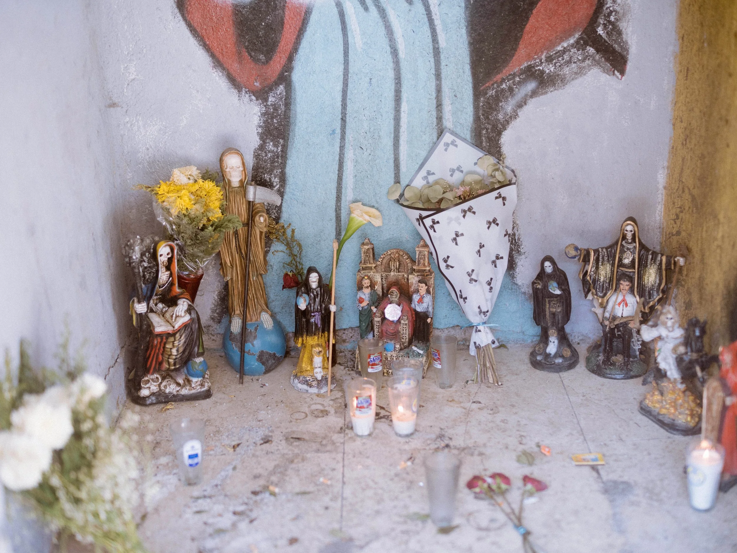 Figurines of Santa Muerte and other religious icons are placed inside a roadside shrine in Tierra Caliente, Michoacán, Mexico.