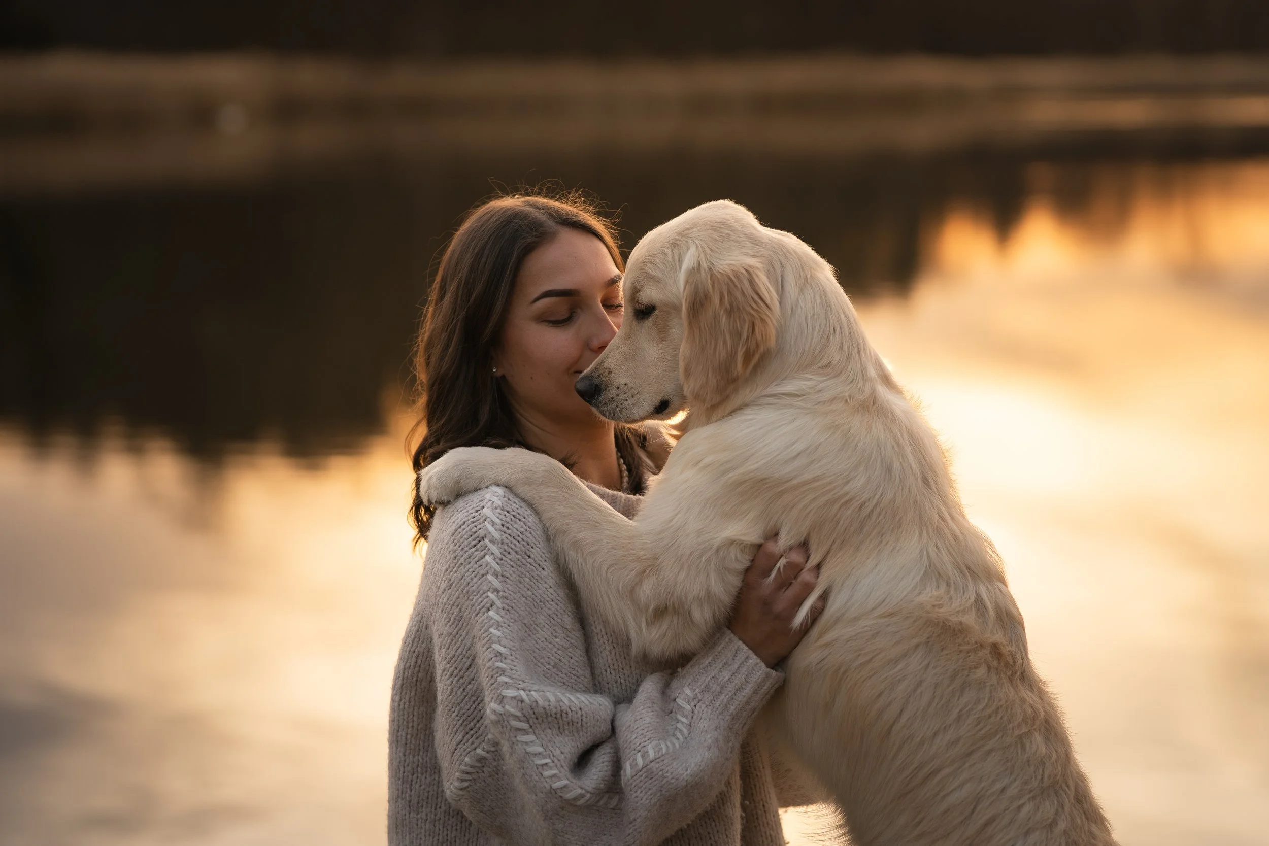 Frau mit Hund zum Sonnenuntergang am See