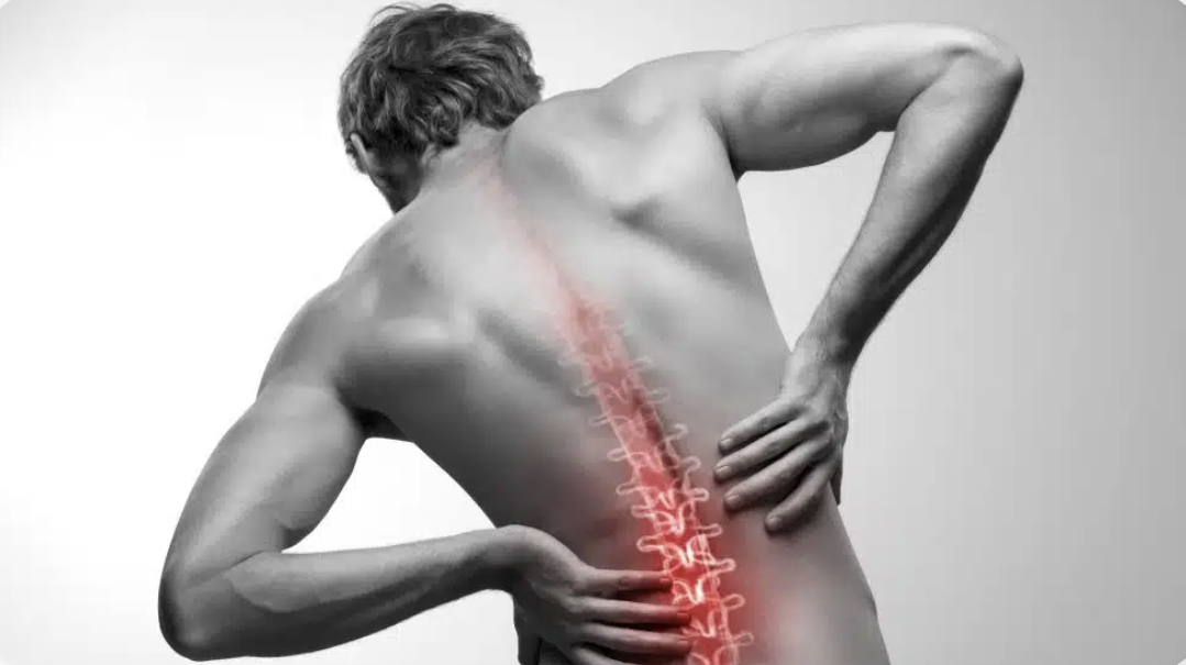 Man with highlighted spine holding lower back in pain