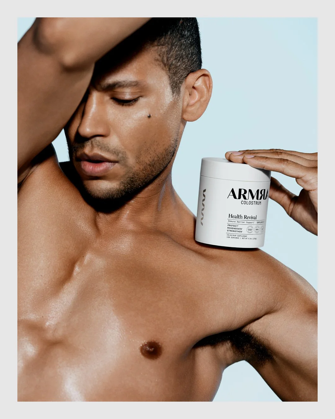 Male model holding ARMRA Health Revival colostrum product