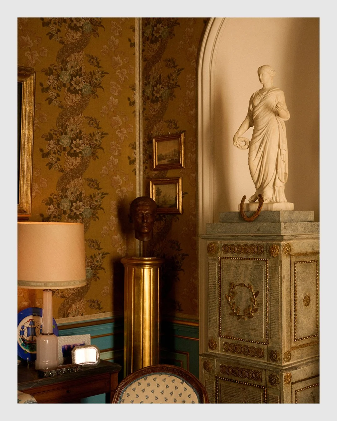 Interior detail from the royal residence with sculpture, artwork and floral wallpaper