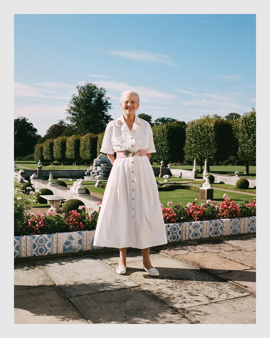 Queen Margrethe II standing in the formal royal garden