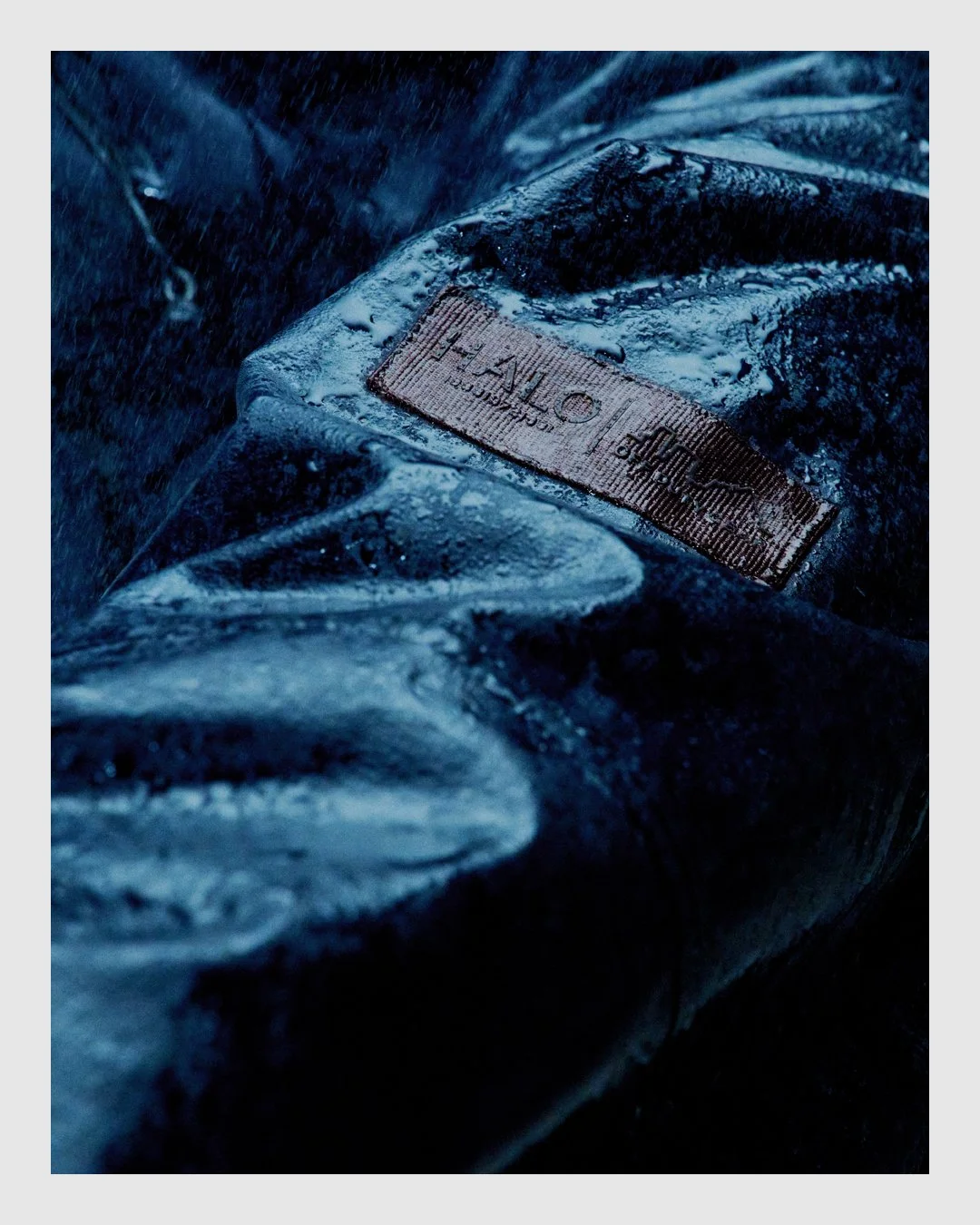 Close-up of HALO technical garment label and wet fabric texture