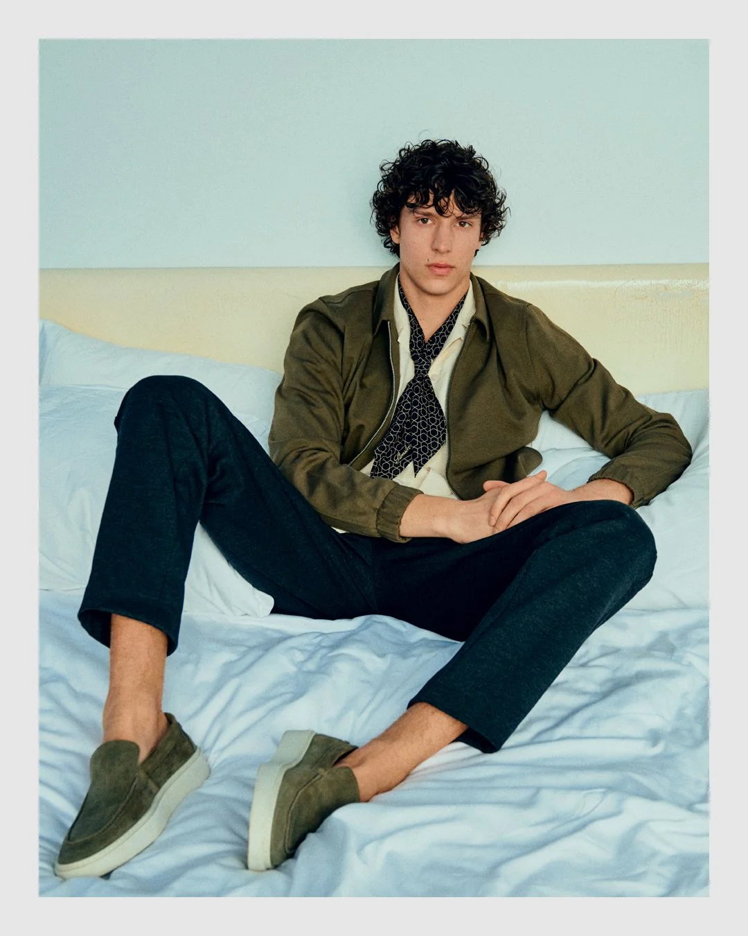 Lindbergh menswear campaign with male model seated on a bed