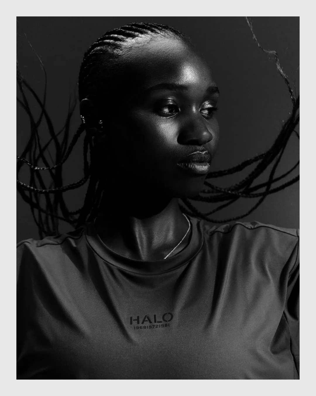 Black and white HALO campaign portrait with braided hair and dramatic lighting