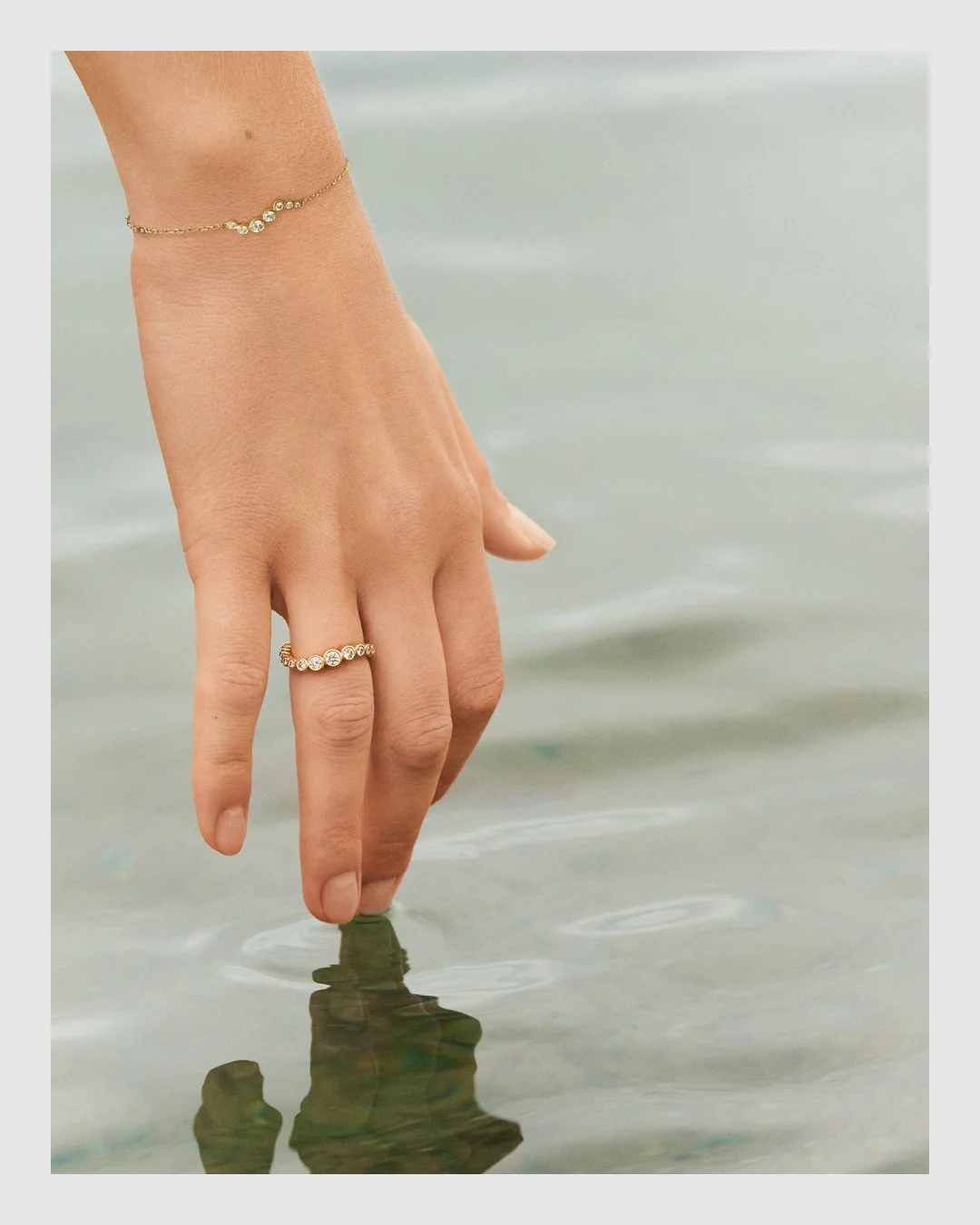 Close-up of Cherituelle diamond ring and bracelet worn beside the water – fine jewelry retouching by Le Lemon