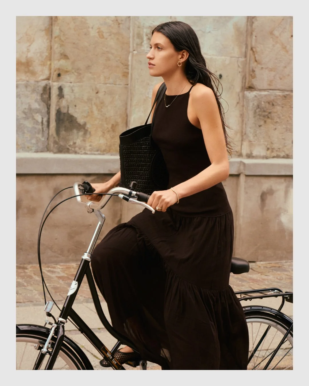Model wearing Cherituelle gold and diamond jewelry while cycling in Copenhagen – lifestyle jewelry campaign retouching by Le Lemon