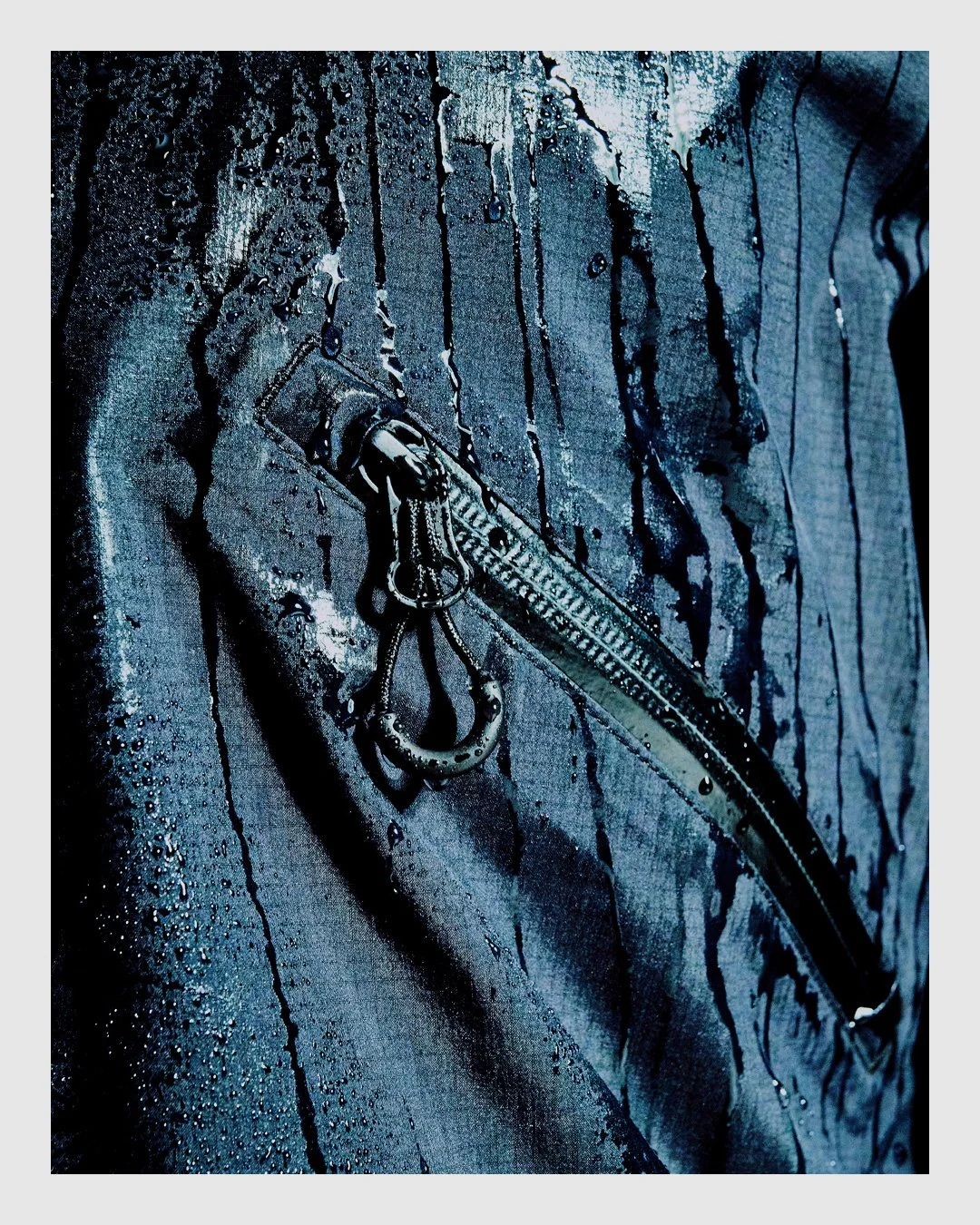 Close-up of wet HALO technical outerwear showing fabric, zipper and water detail
