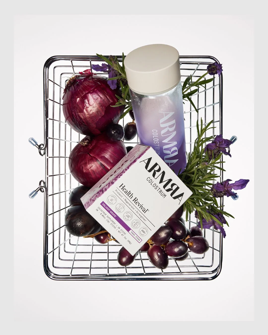 ARMRA colostrum products arranged in a shopping basket with red onions and grapes