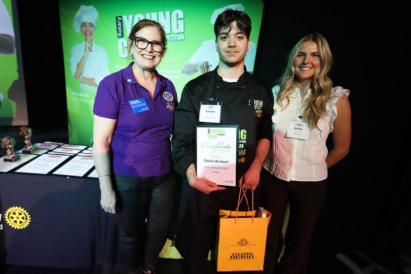 Three people in a photo with one holding a certificate