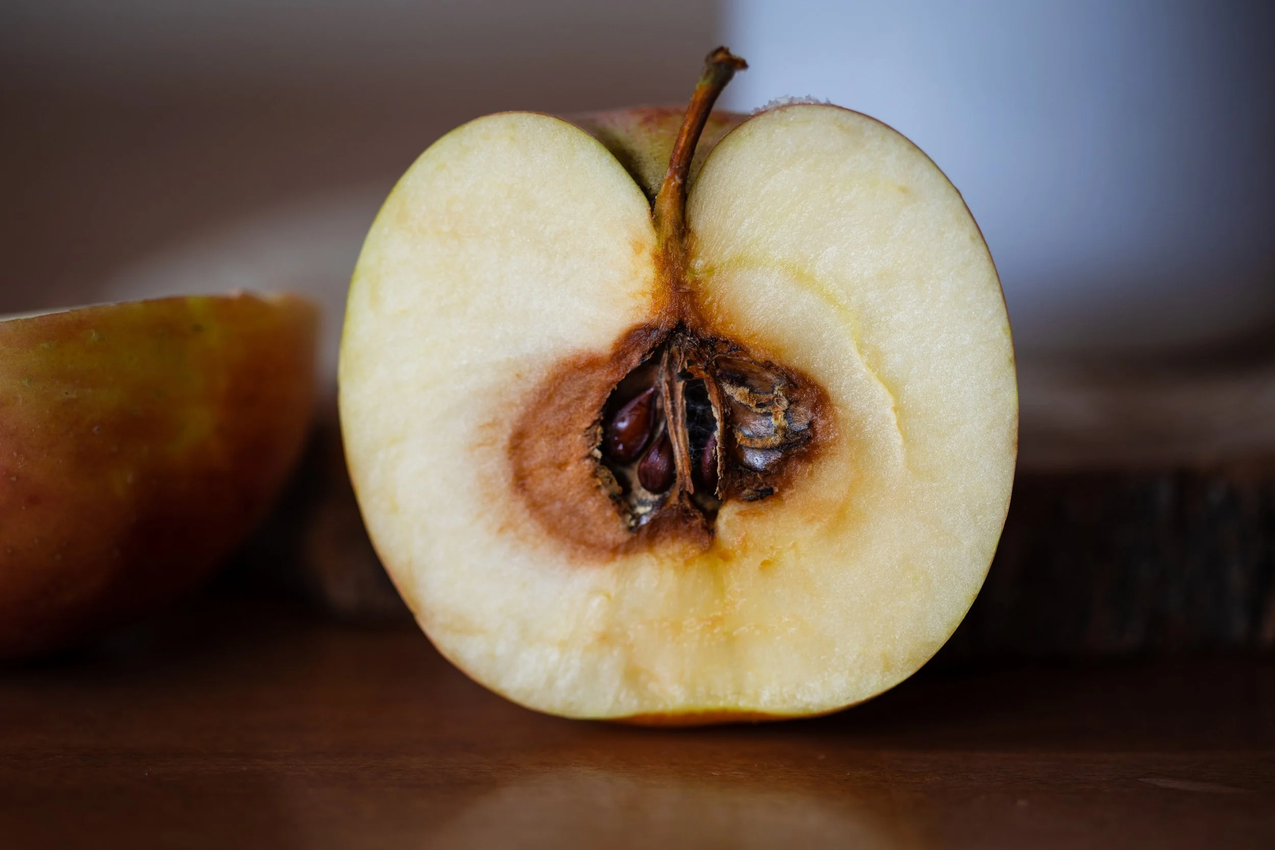 Cut apple with a dark, rotting core, symbolizing systemic failure and hidden harm in Massachusetts child welfare and DCF oversight.