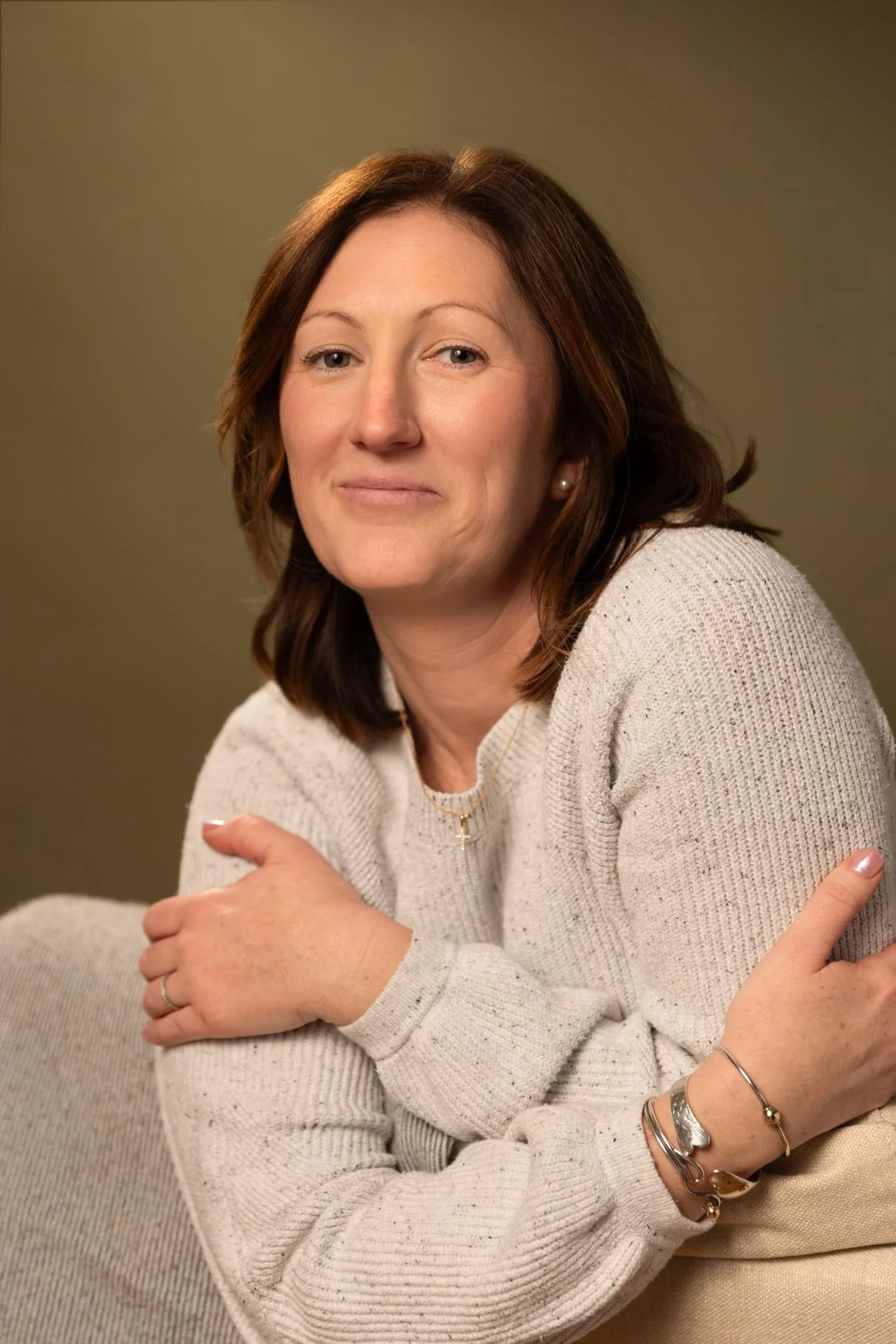 Chelsy Catsam, a trauma therapist in York, PA, smiles while sitting in a white chair.