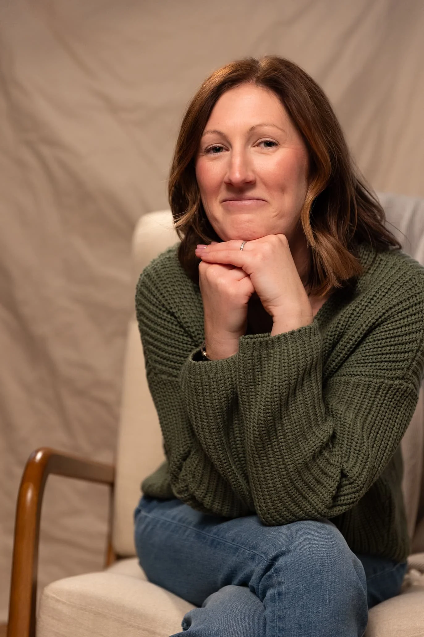 Chelsy Catsam, a women's health therapist in York, PA, smiles while sitting in a white chair.