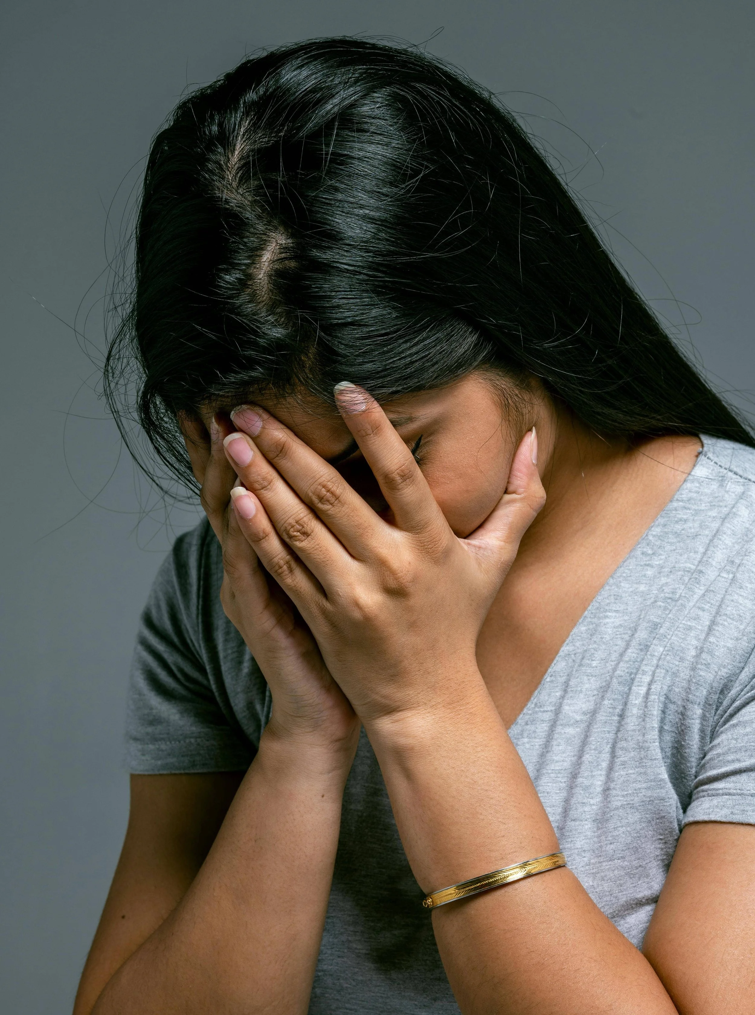 In York, PA, a woman holds her head in her hands during an individual therapy session with Catsam Wellness.