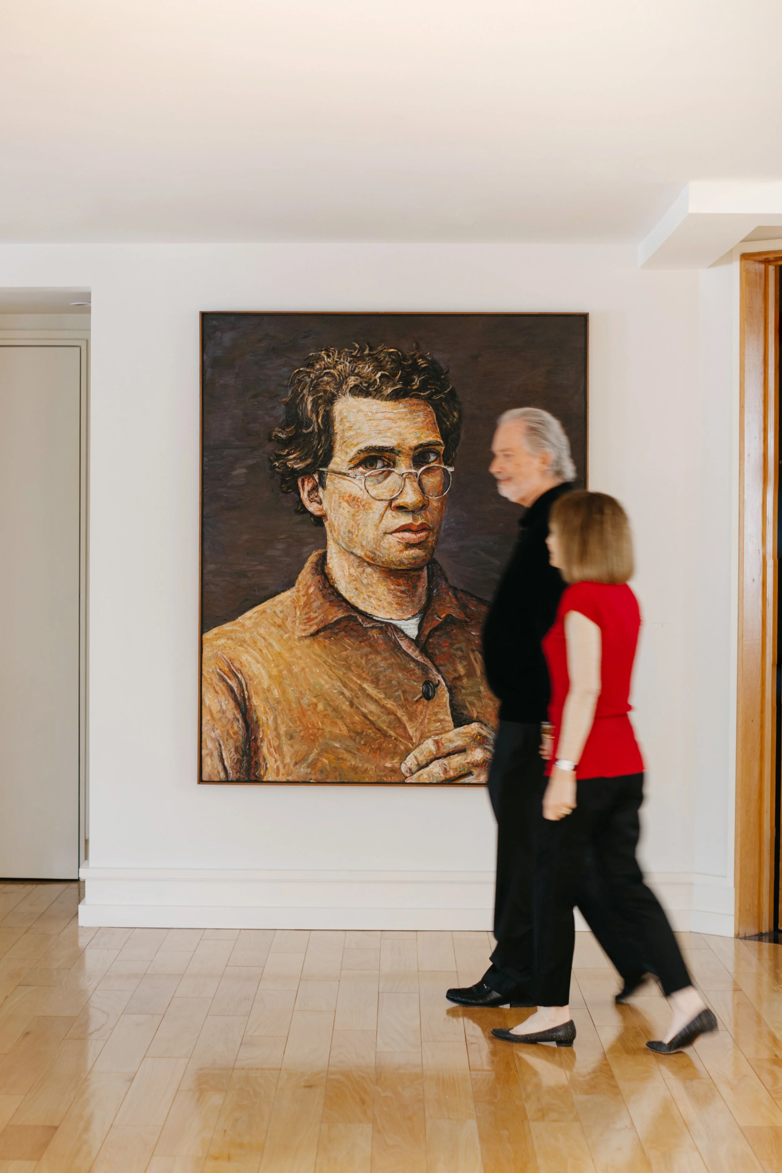 Couple walking by art in hallway
