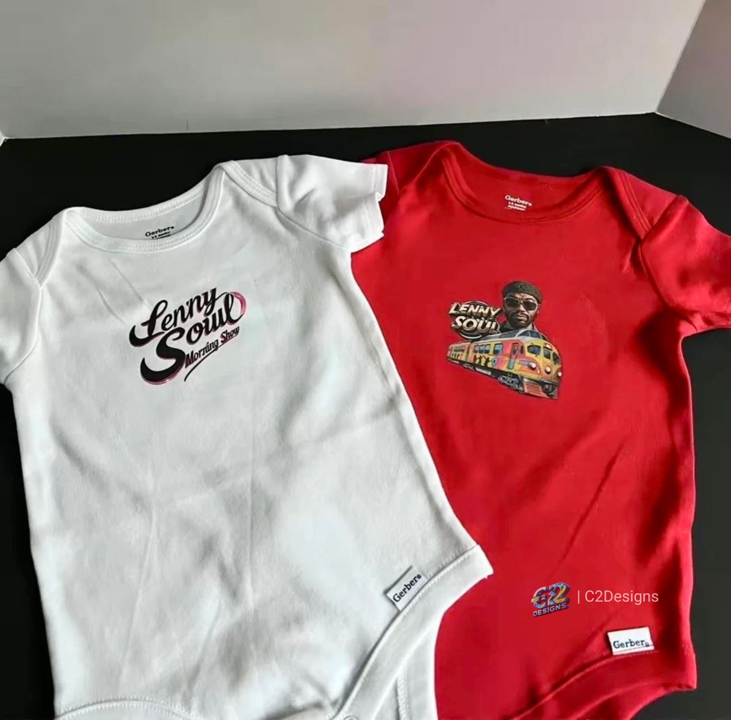 Two short-sleeve T-shirts, one white with 'Lenny Soul Morning Show' logo and the other red with a graphic of a man, sunglasses, and a colorful train.