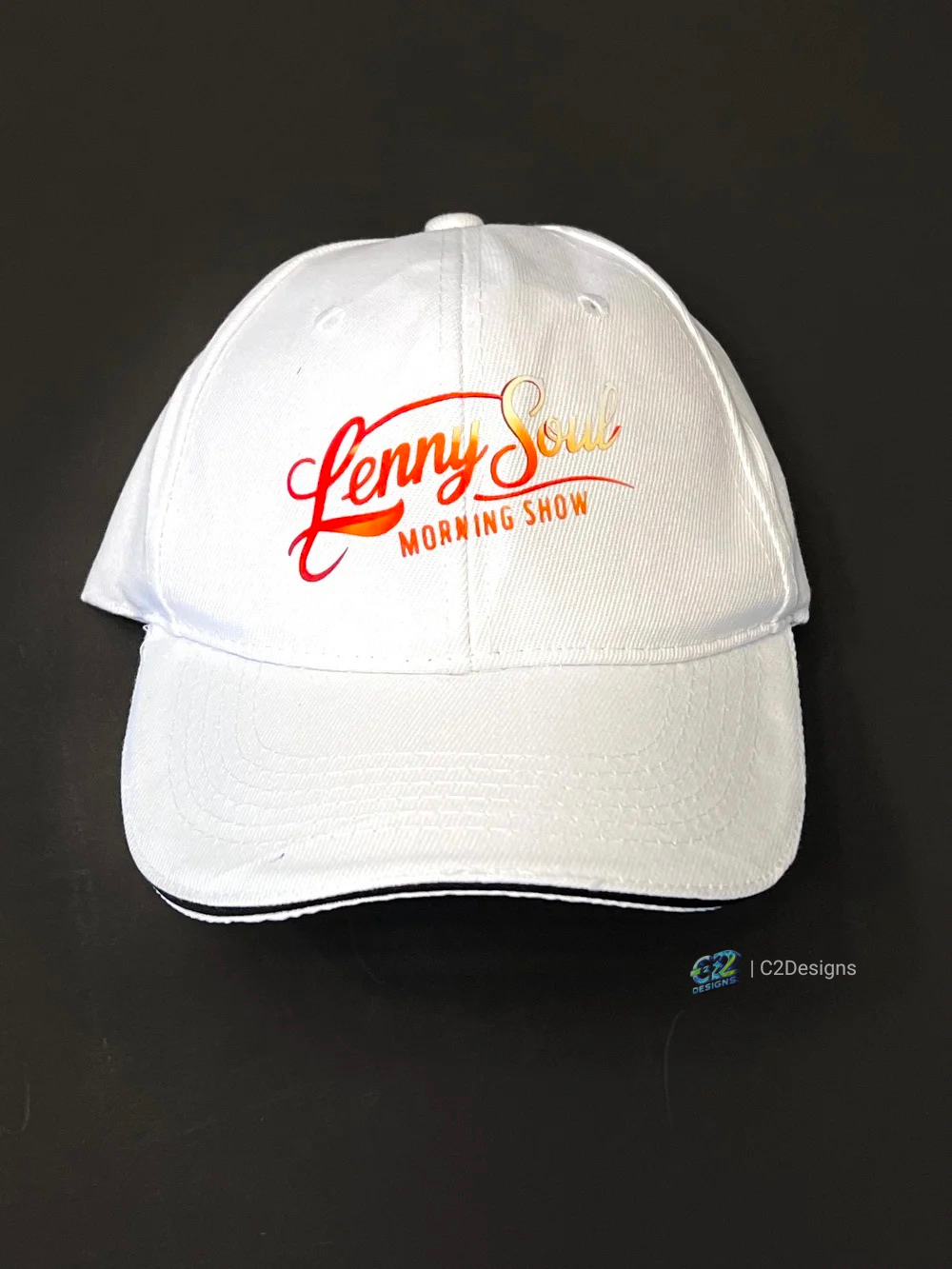 White baseball cap with logo reading "Lenny Soul Morning Show" in red, orange, and yellow lettering on a black background.