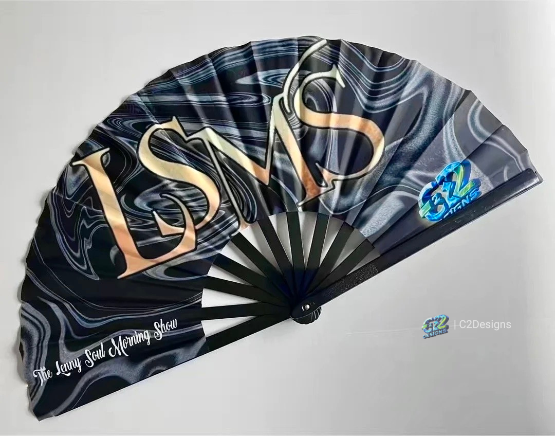 A black folding fan with abstract swirl patterns and large gold letters spelling LMSD. The fan also features a blue and green logo in the lower right corner and the phrase "The Lenny Soul Morning Show" written in white script on the lower left side.