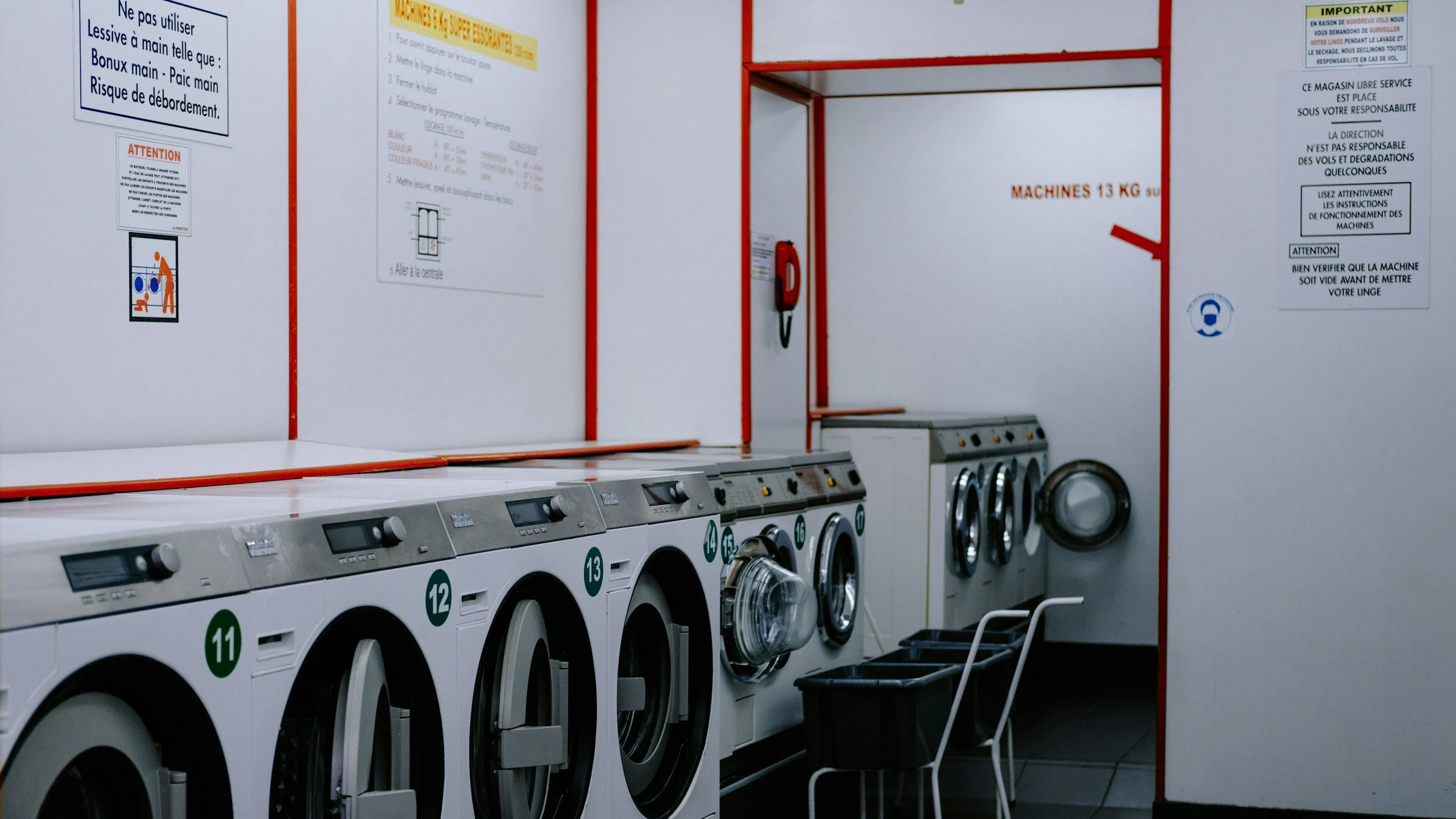Row of coin-operated laundry washing machines in a laundromat