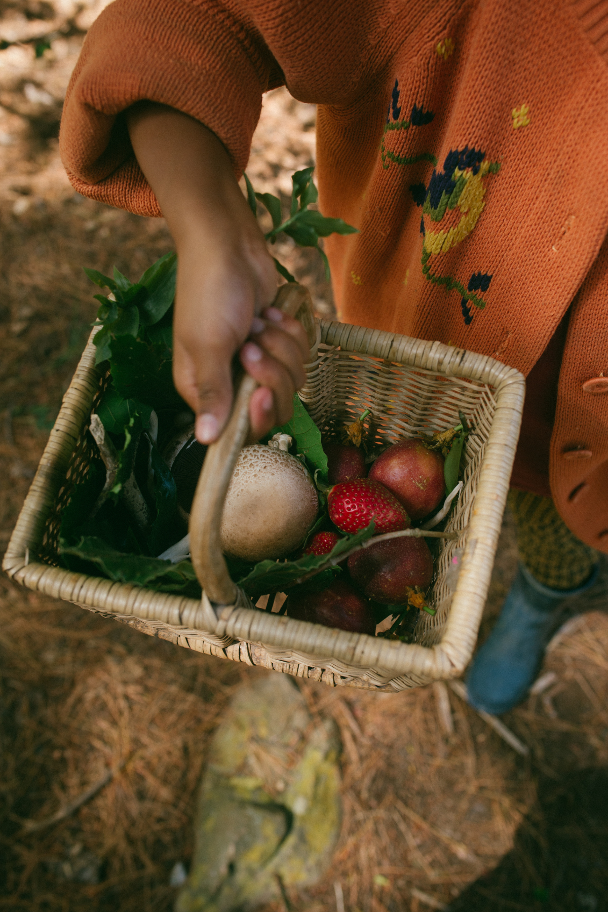 a girl holding a basket of fruits and vegetables