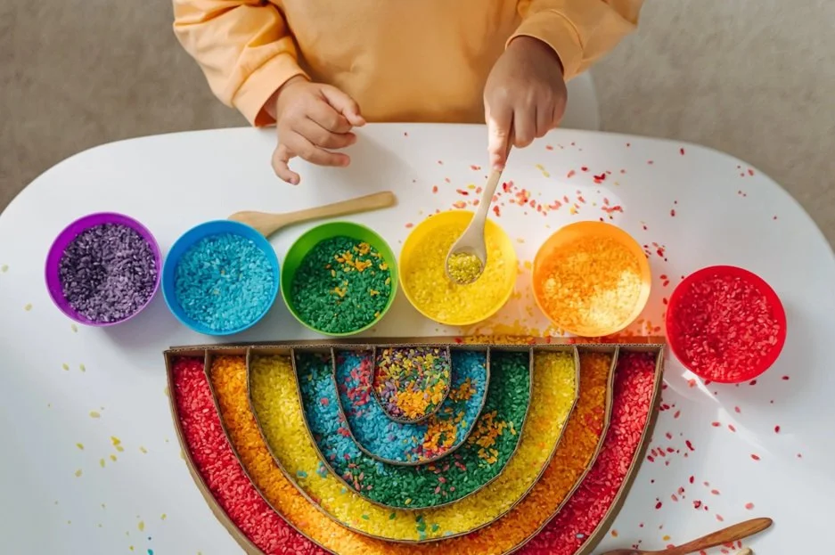 Kid having fun with rainbow color sensory play