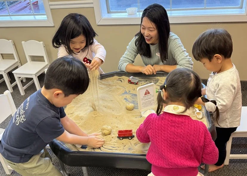 Kids playing with sand on messy play table