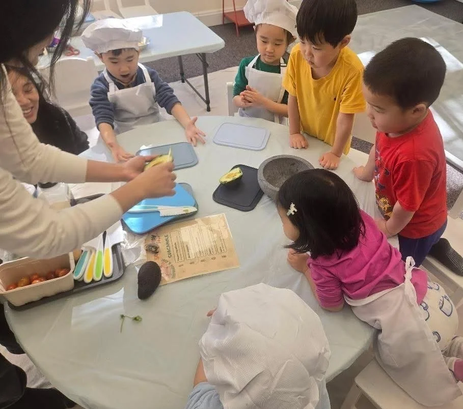Kids looking at Miss Charry for cooking instruction