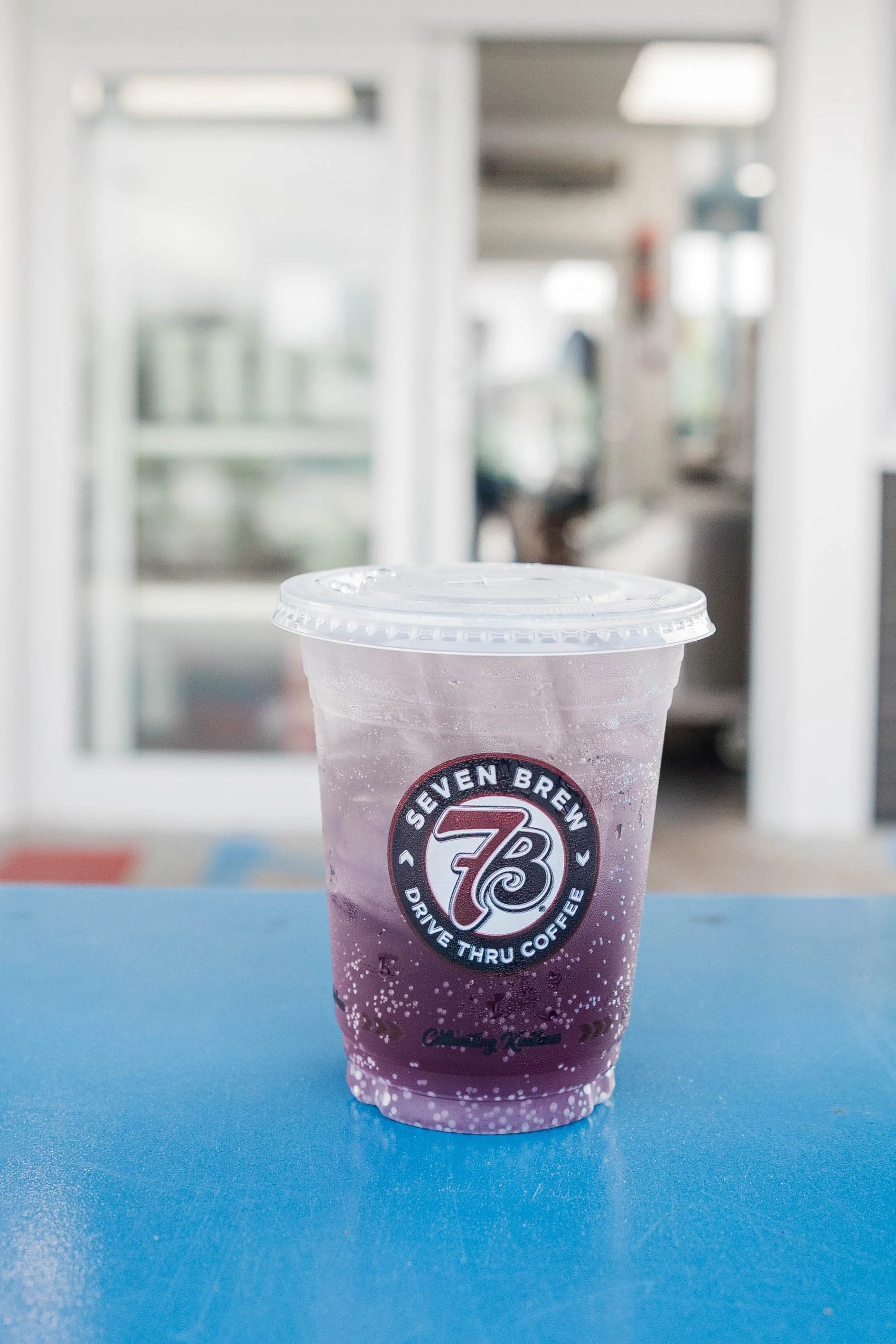plastic-cup-of-purple-drink-with-ice-branded-seven-brew-on-b.jpg