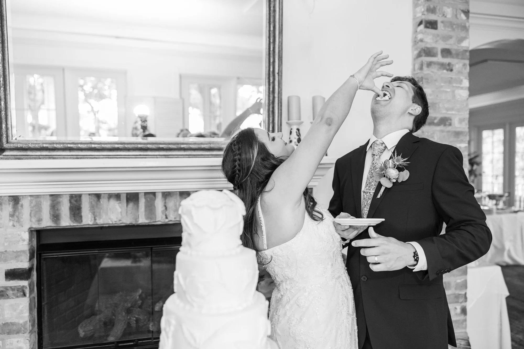 bride-and-groom-laughing-while-feeding-each-other-cake-in-a.jpg