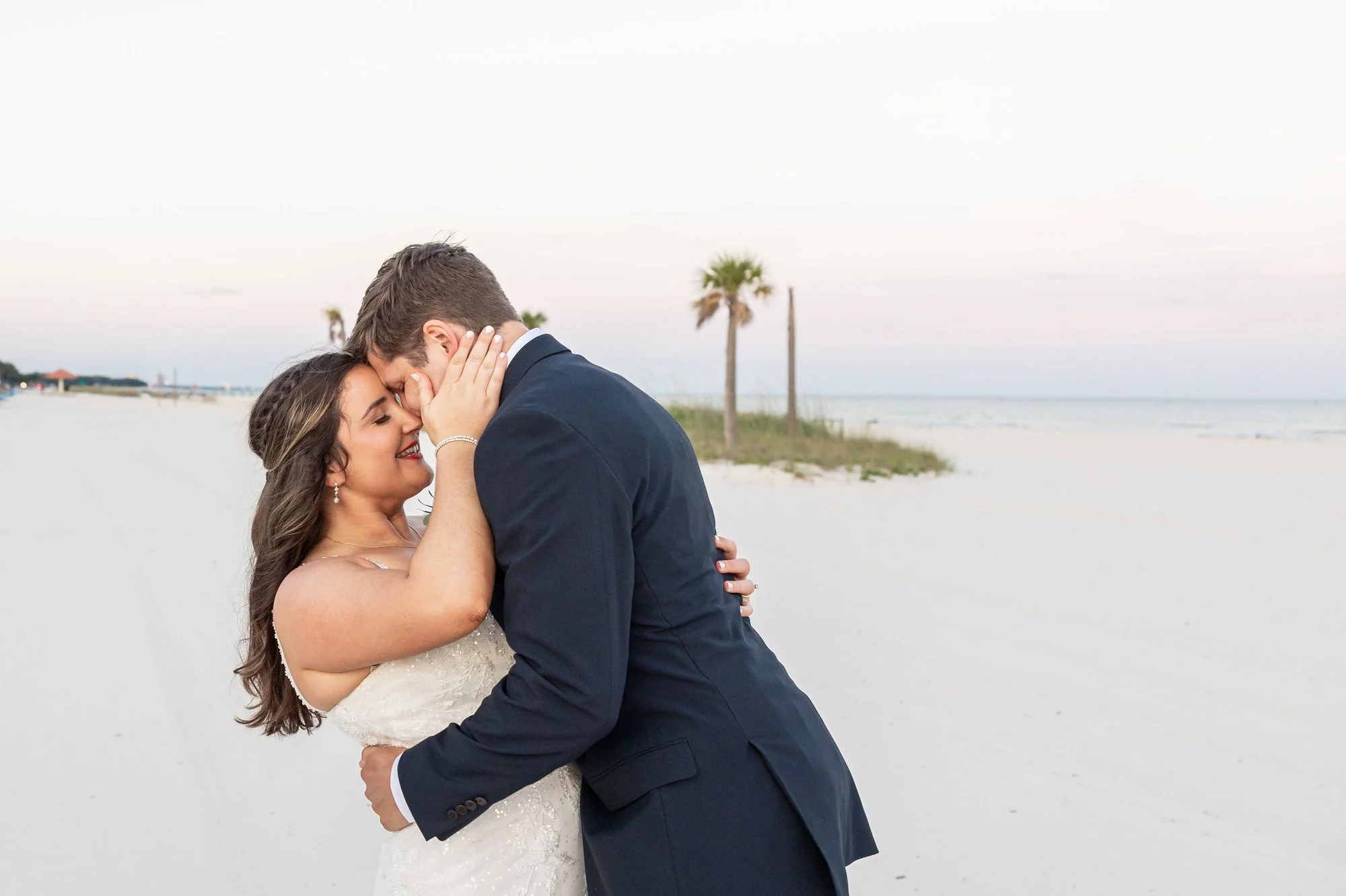 bride-and-groom-embrace-on-a-serene-palm-lined-beach-at-suns.jpg
