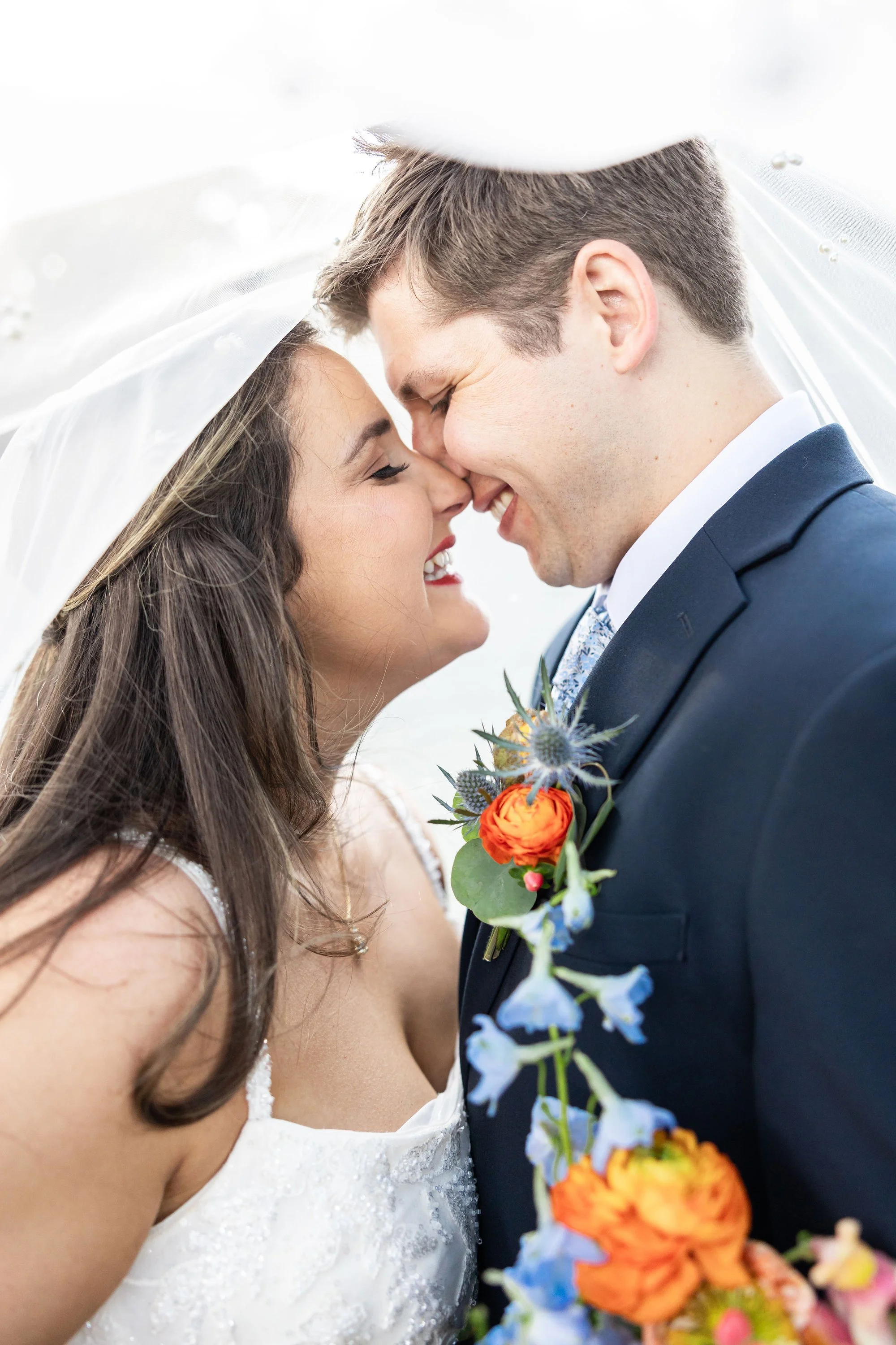 bride-and-groom-sharing-a-joyful-moment-under-a-veil-wearing.jpg