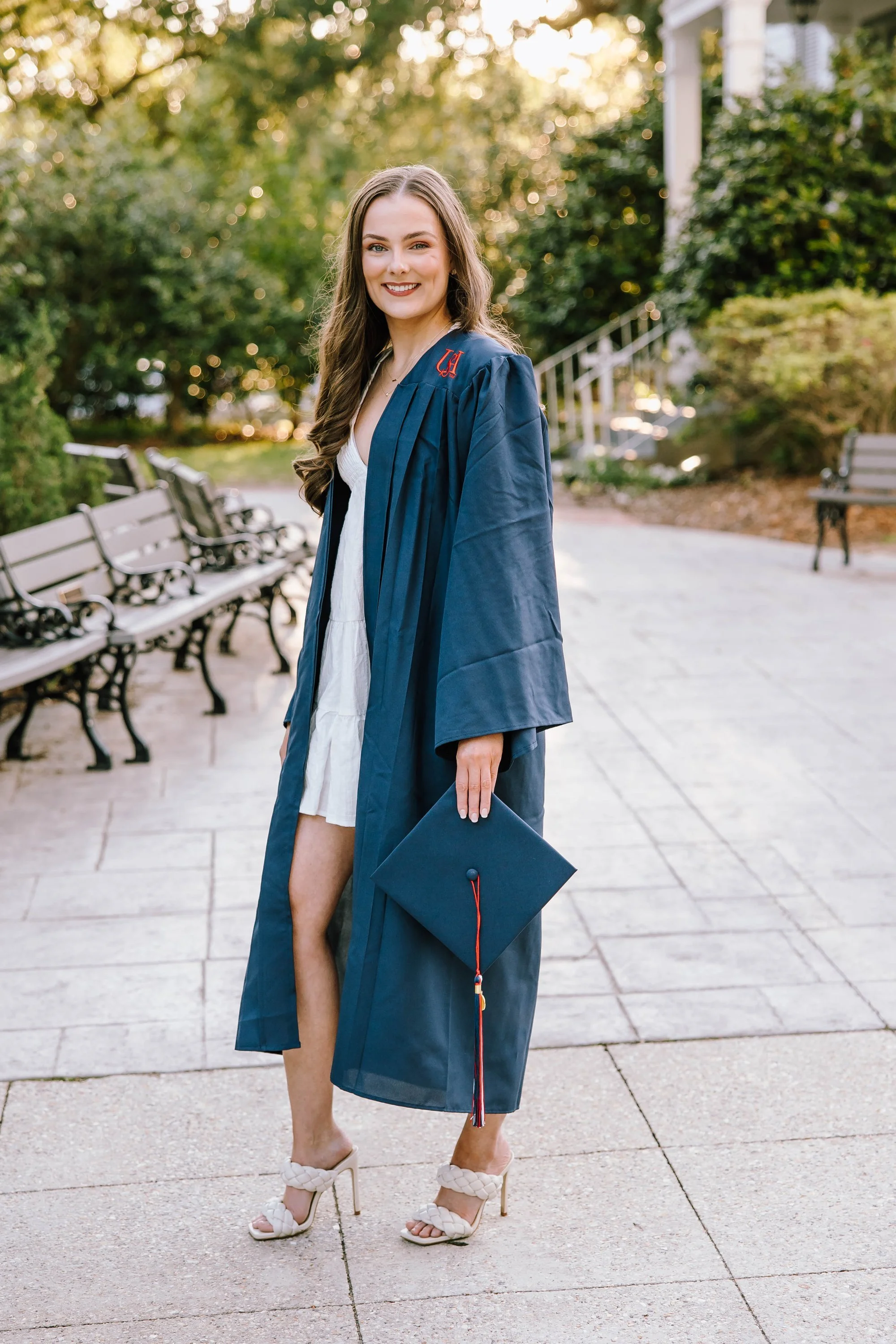 woman-in-graduation-gown-holding-cap-smiling-outdoors-on-a-s.jpg