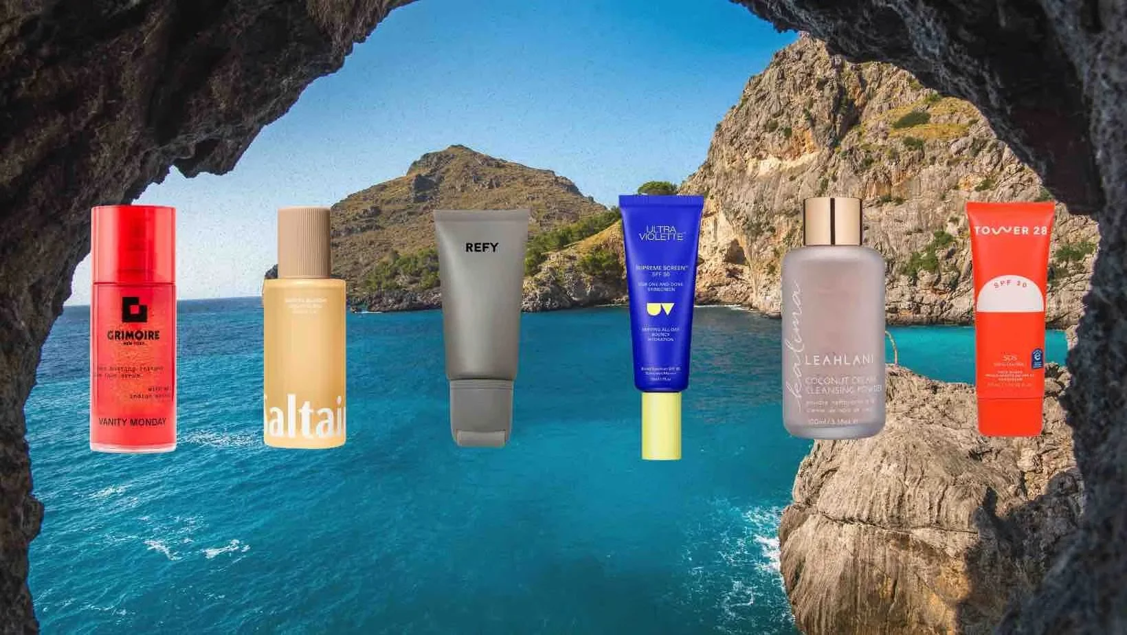Seven skincare or cosmetic products displayed in a scenic rocky seaside view, framed by a natural rock arch with blue sea and green cliffs in the background.
